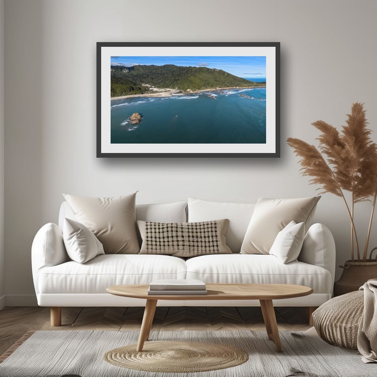 Aerial coastal landscape with offshore rock formation and rugged shoreline.