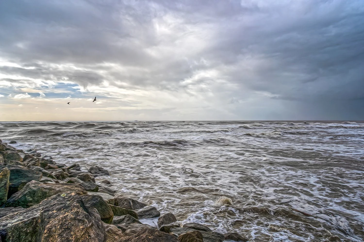 Storm clouds and ocean waves along the West Coast shoreline.