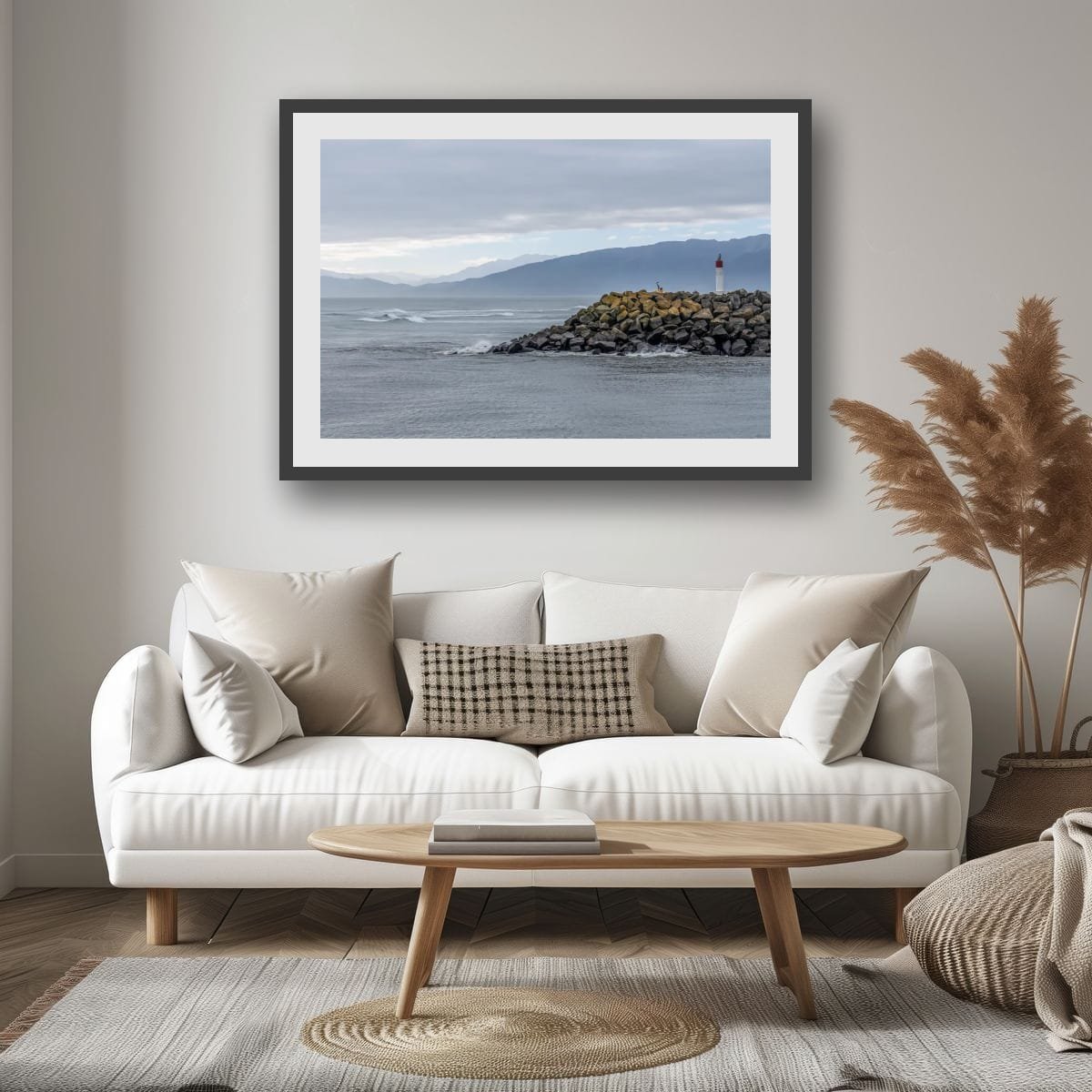 Beacon on a rocky breakwater with mountains beyond on New Zealand's West Coast.
