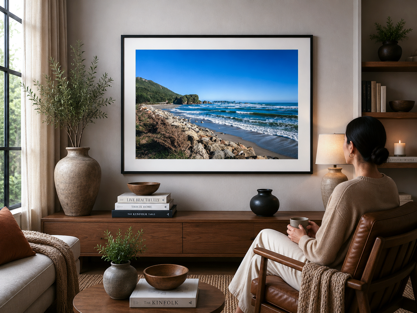 Waves rolling onto a rocky West Coast beach with distant sea stacks beneath a clear blue sky.