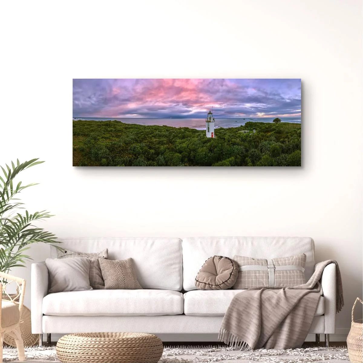 Panoramic view of a historic lighthouse surrounded by native bush at sunset.