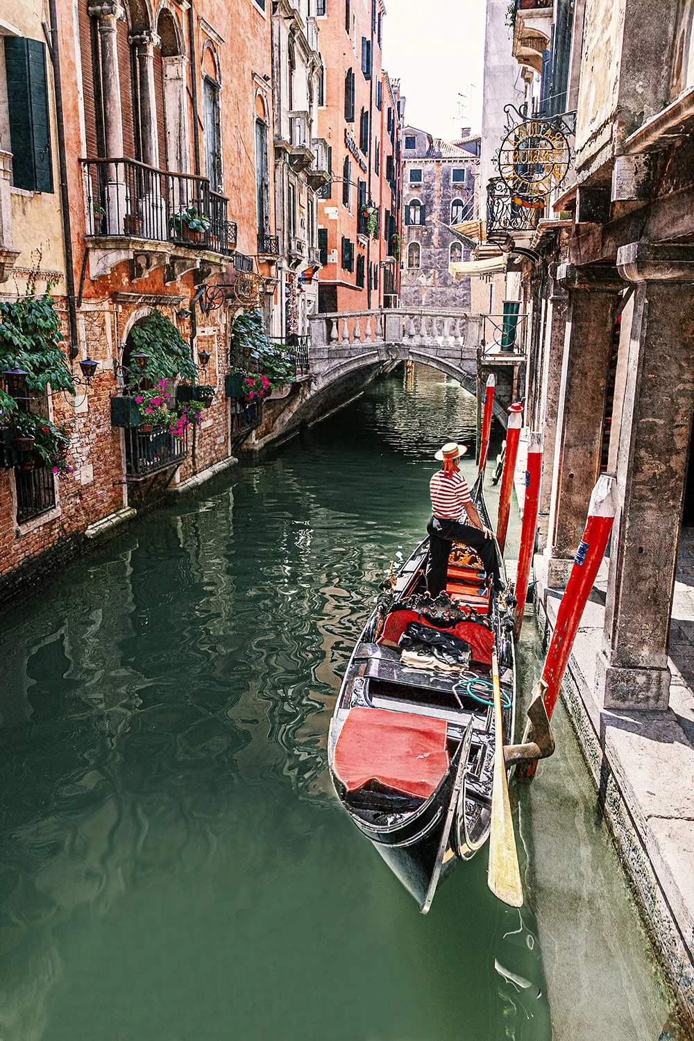 Gondola travelling through a Venetian canal surrounded by historic buildings.
