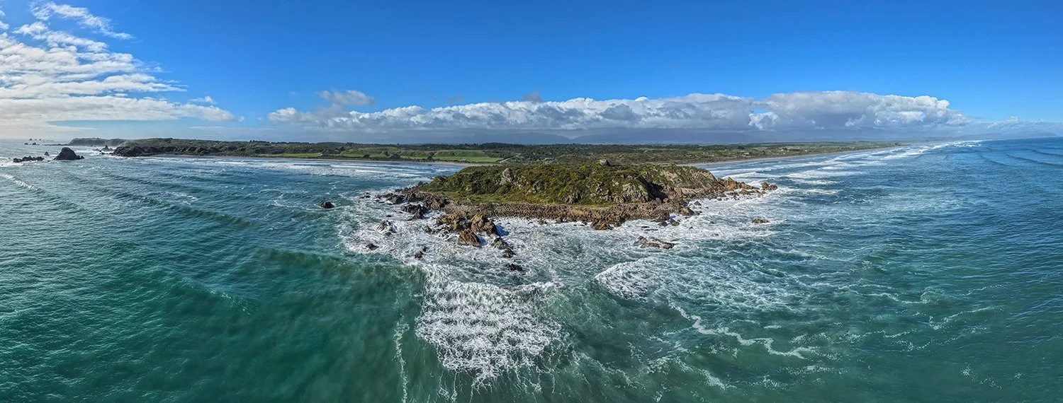 Aerial view of ocean currents moving around coastal rocks and reefs.