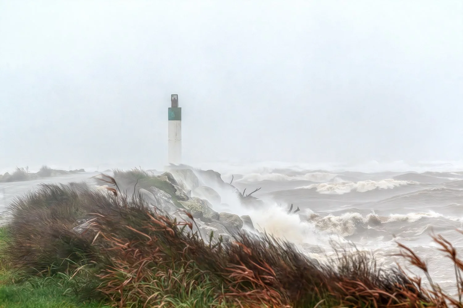 Coastal beacon standing against rough seas and stormy weather.