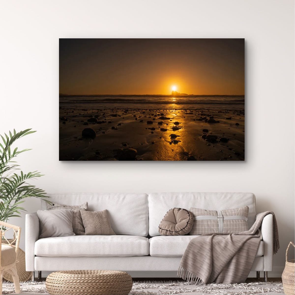 Golden sunset reflecting across wet sand and stones with offshore rock on the West Coast.