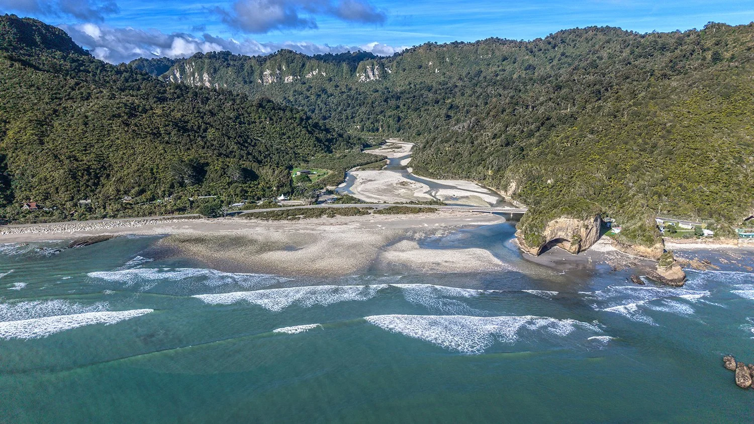 Aerial view of river mouth, beach and ocean waves on the West Coast.