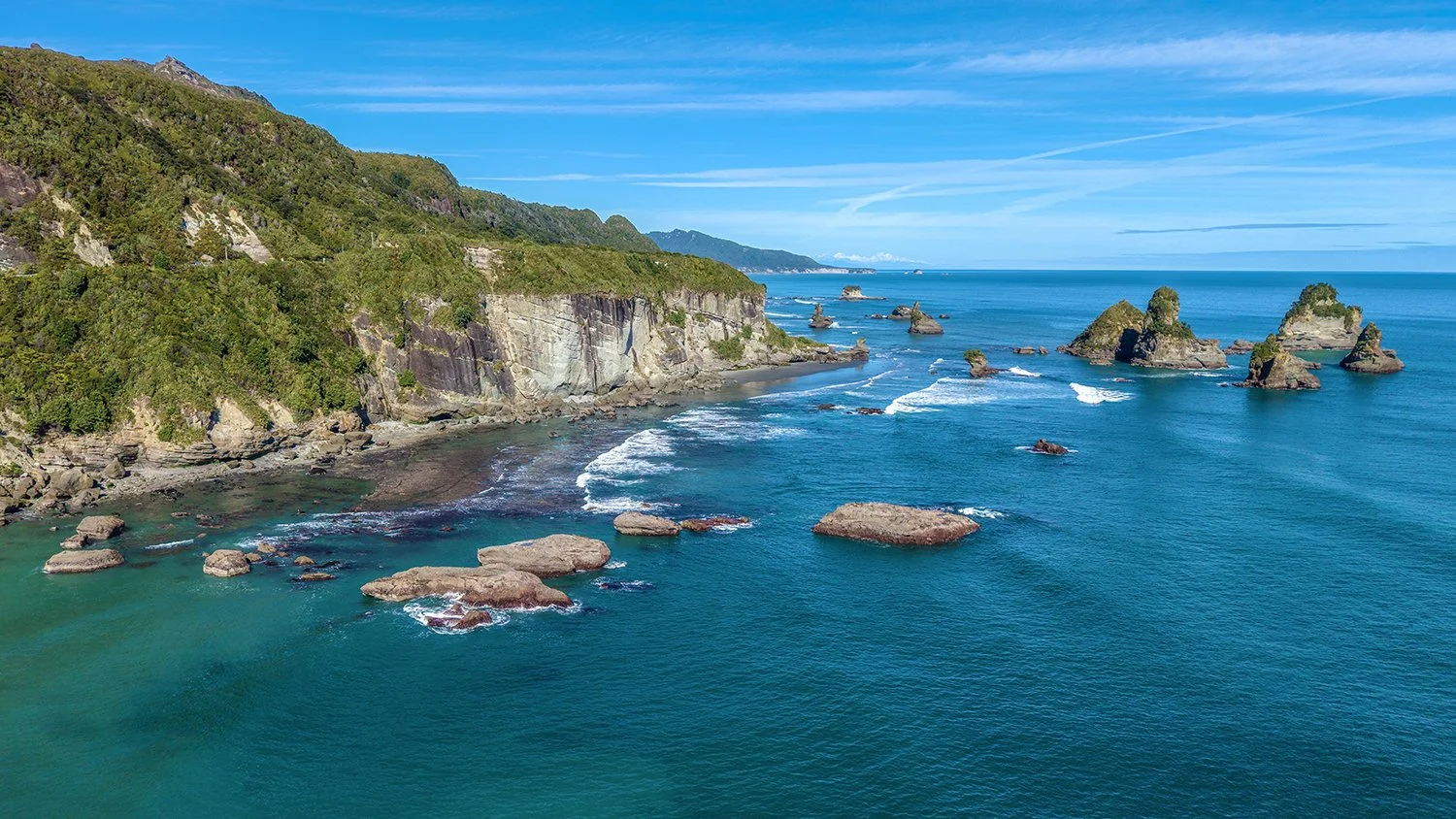 Aerial coastal view of West Coast cliffs and sea stacks.