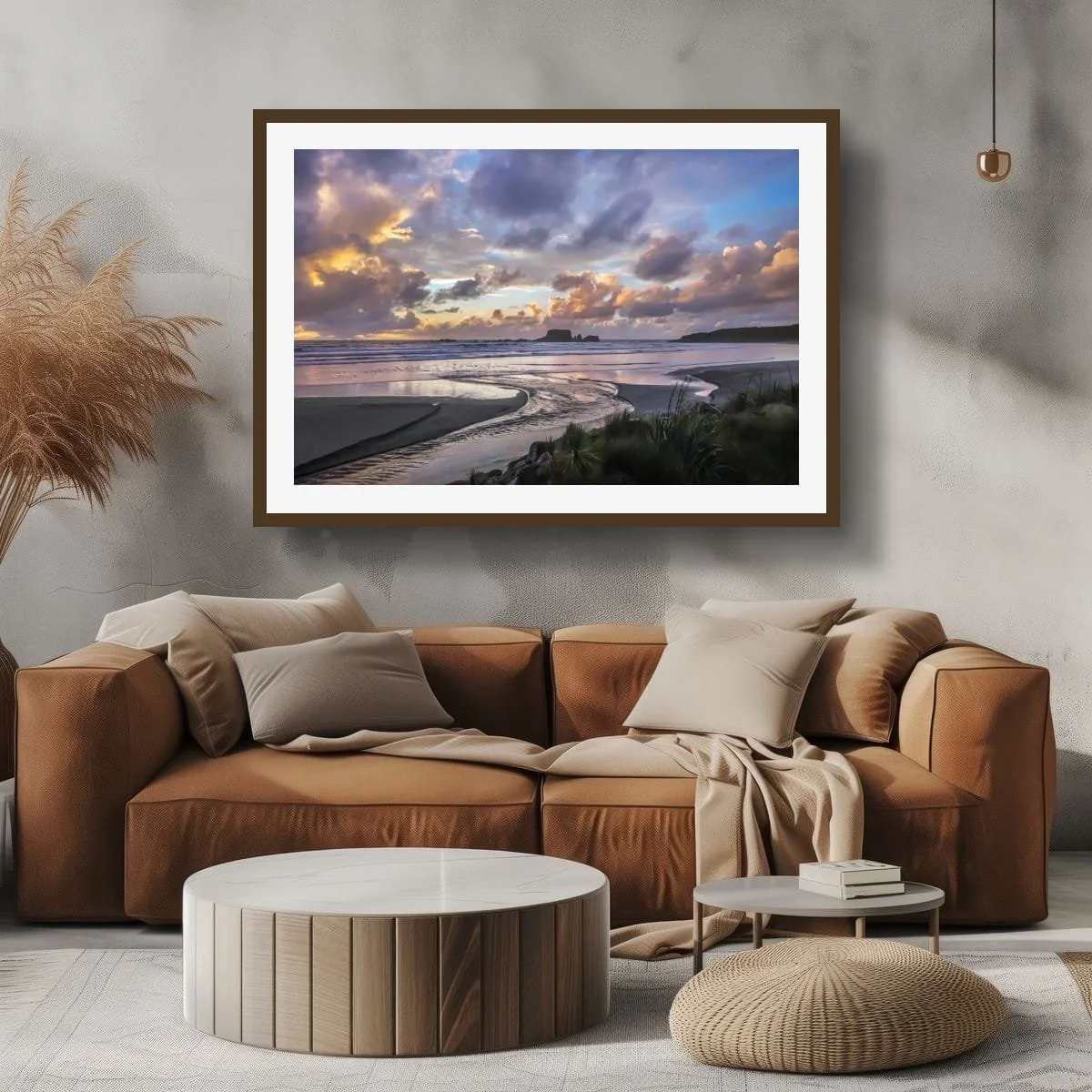 Curving tidal stream on a beach beneath pastel blue, mauve and peach clouds with offshore rock formations.