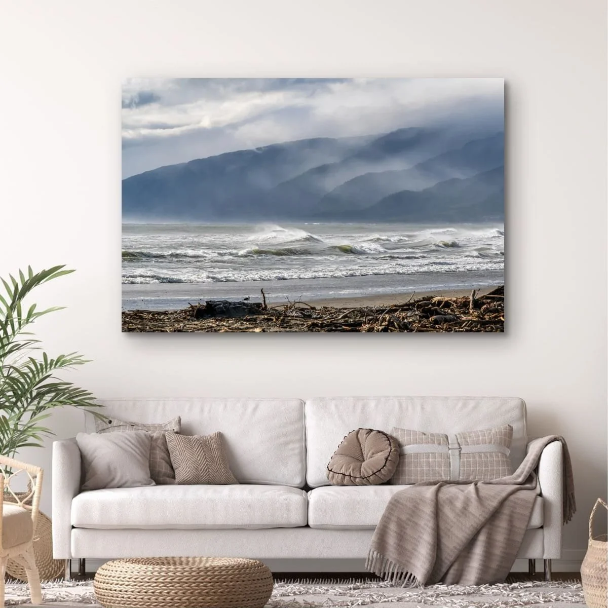 Sea spray blowing across waves beneath misty mountain ranges.
