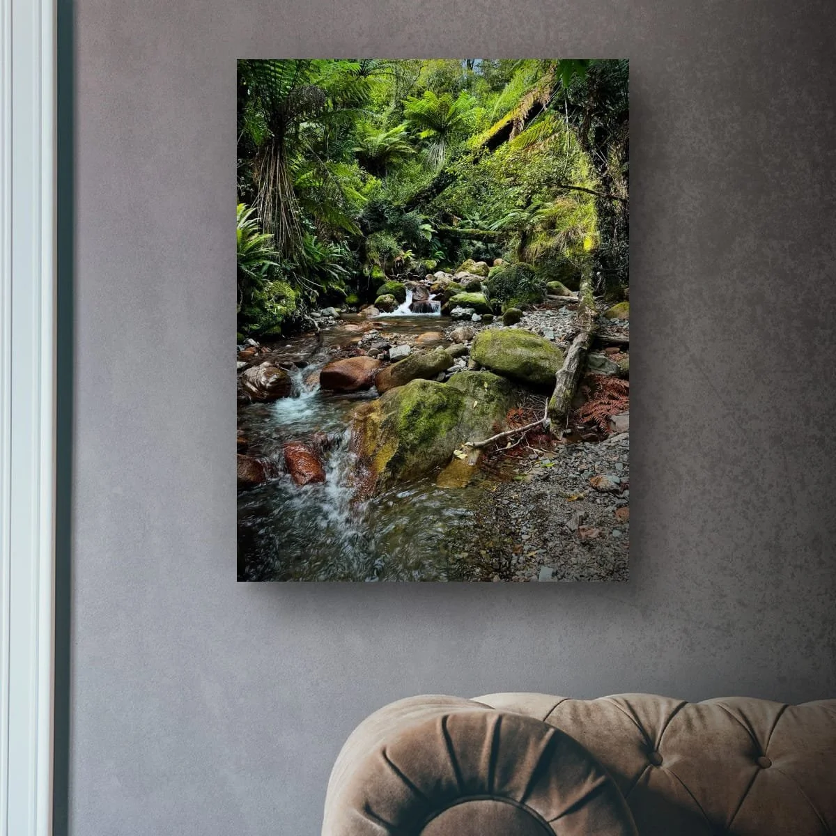 Native forest stream flowing through mossy rocks and ferns.