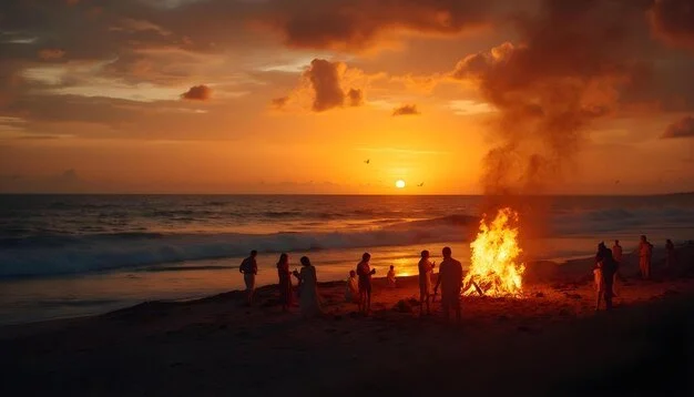 People gathered around a bonfire on a beach during sunset.
