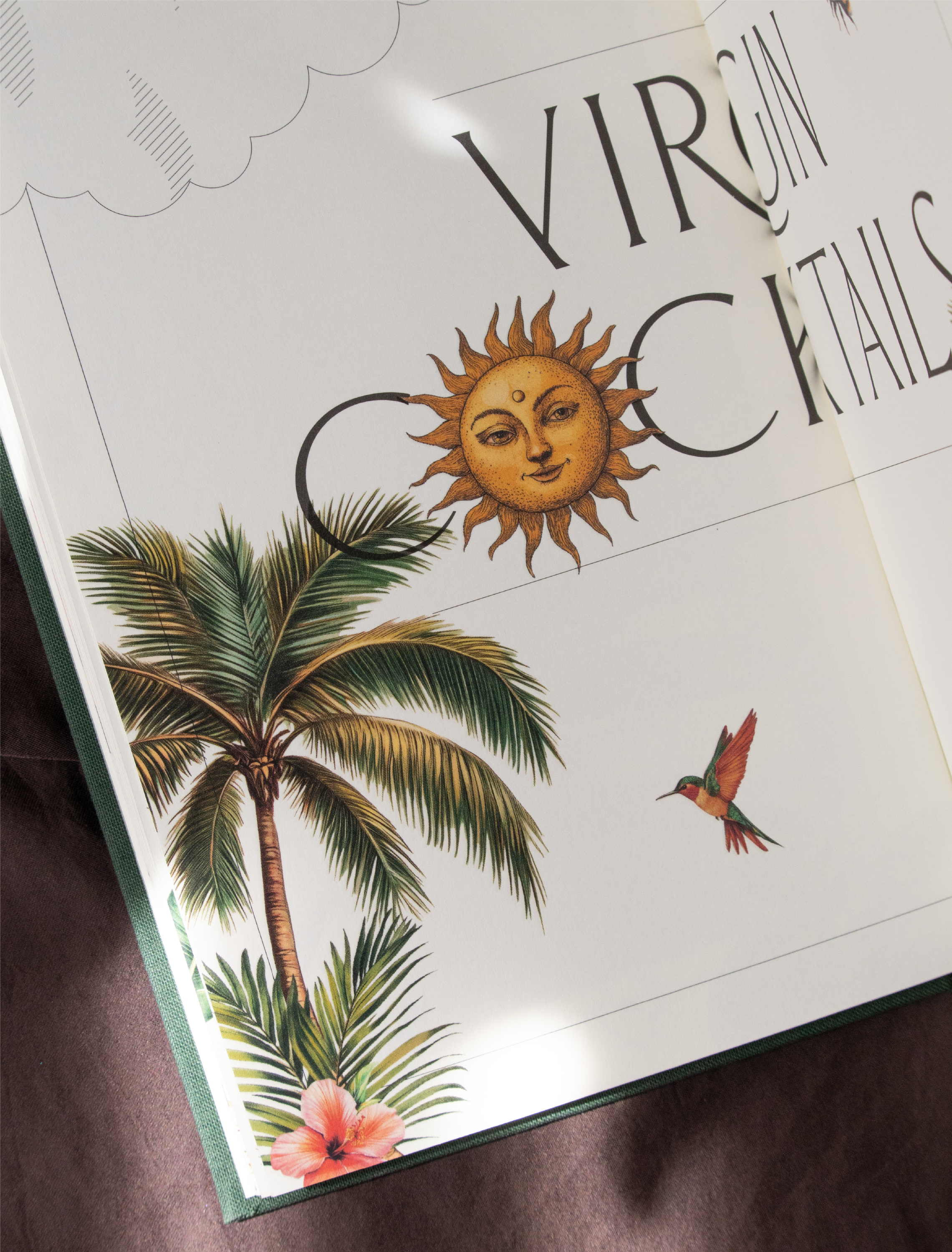 Illustration d'un soleil souriant avec un visage humain, entouré de palmiers, une fleur d'hibiscus rose-orange et un colibri orange et vert, sur une page de livre ou de magazine.