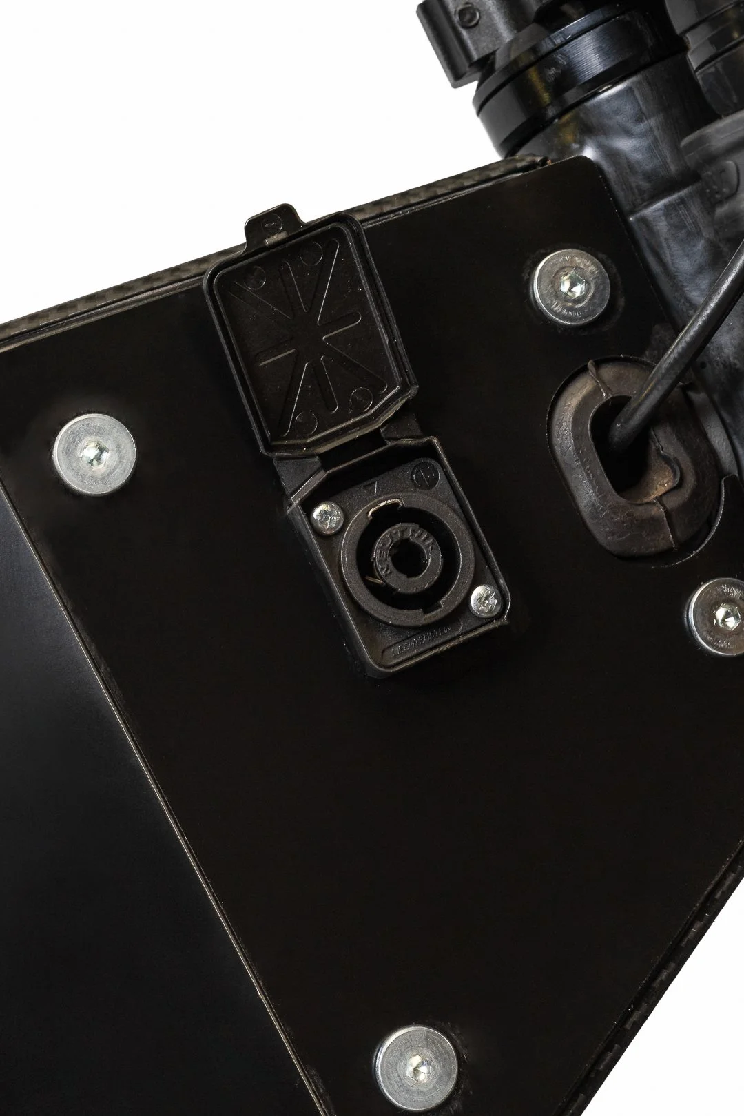 Close-up of a black electronic device with circular connectors and screws, possibly part of a piece of audio or video equipment.