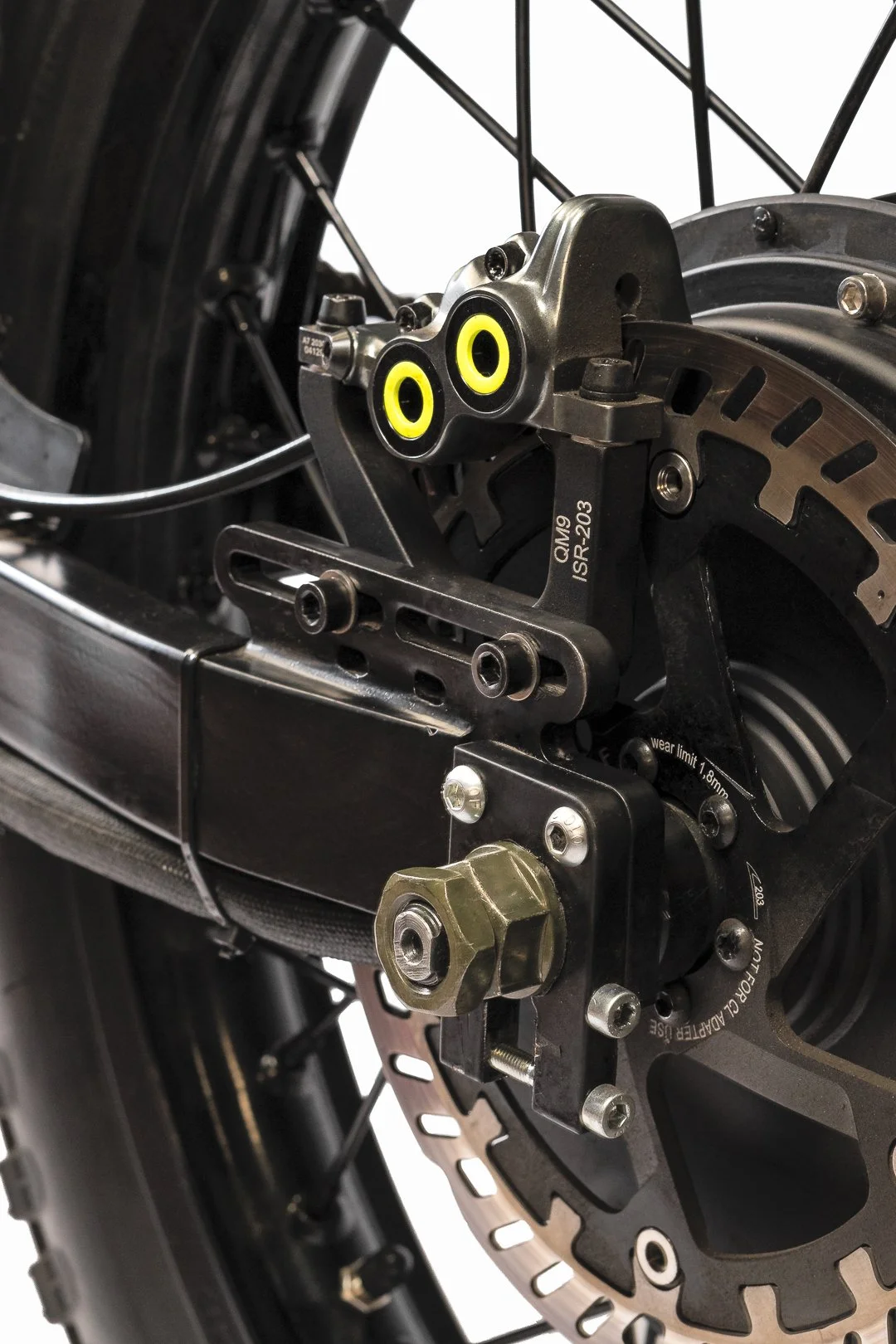Close-up of a motorcycle front disc brake system with caliper and rotor, including mounting hardware and brake line connection.