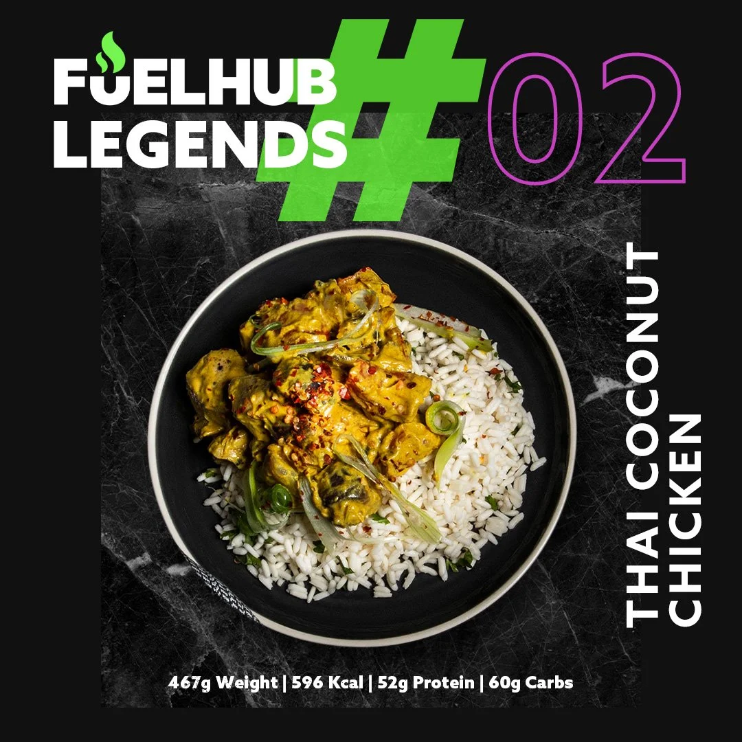 A bowl of Thai coconut chicken served over white rice, garnished with green onions, on a black marble surface with fitness and nutrition information in overlay.