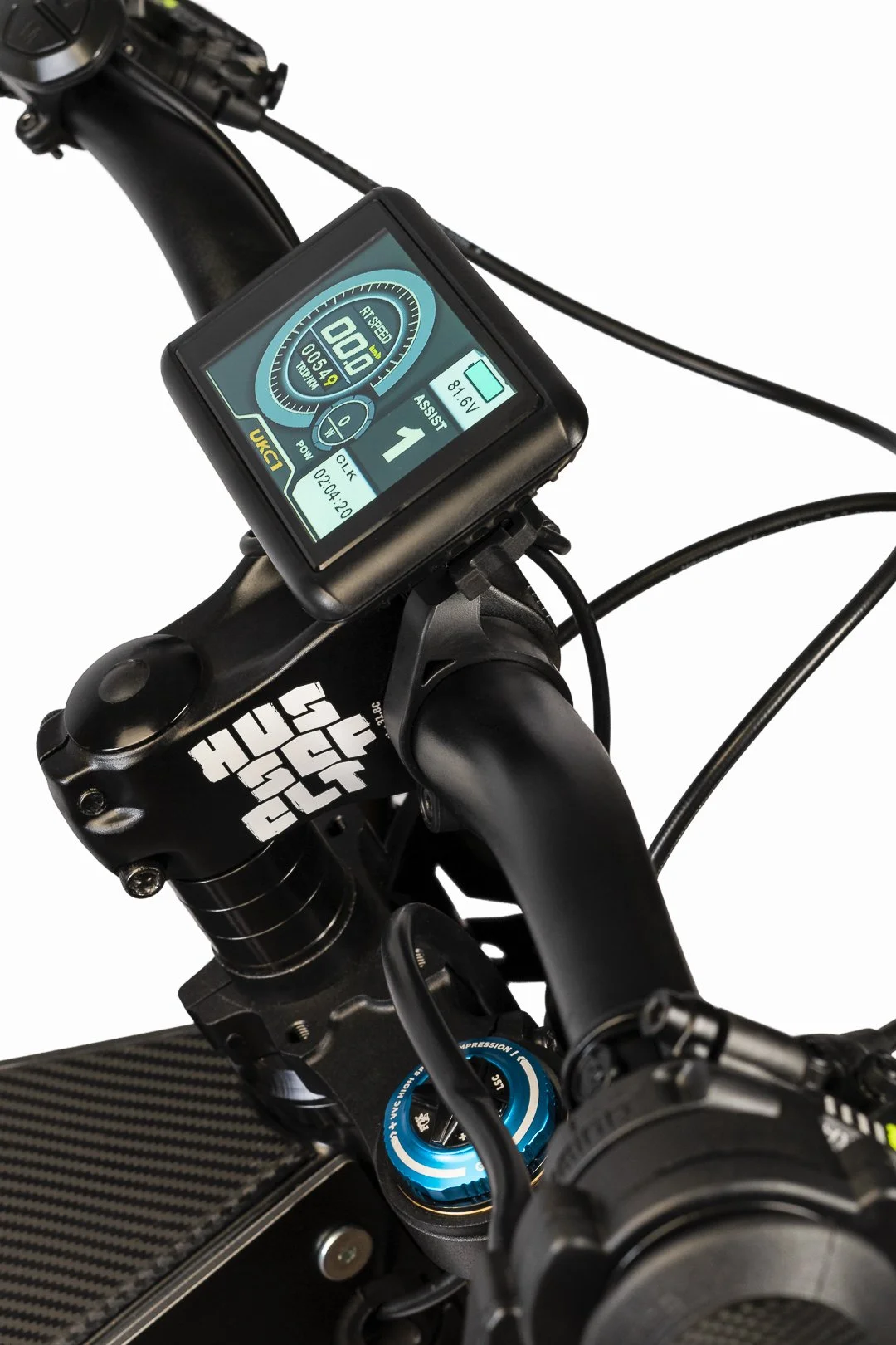Close-up of a bicycle's handlebar with an electronic display showing speed, battery level, and gear, mounted on a black frame.