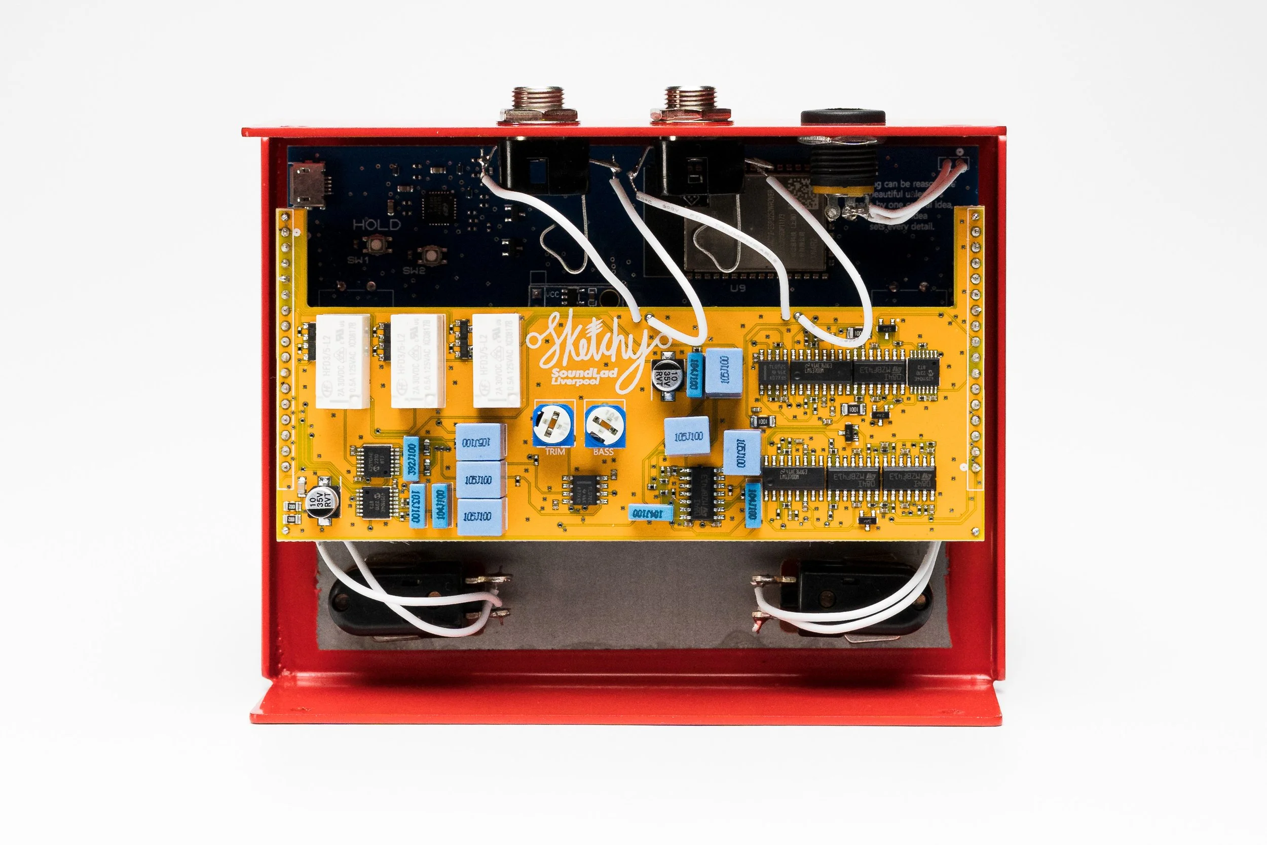 Electronics project inside a red box showing a yellow circuit board with various components and wires.