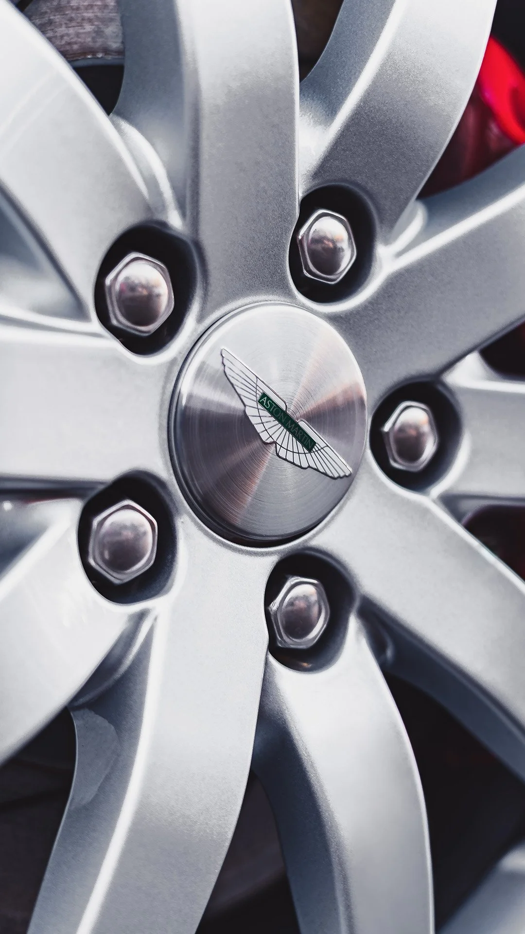 Close-up of an Aston Martin car wheel with a silver finish.