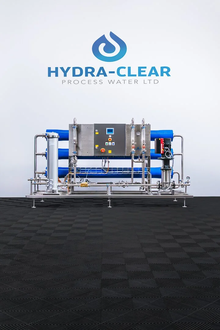 Industrial water filtration system in front of a wall with the Hydra-Clear logo and text