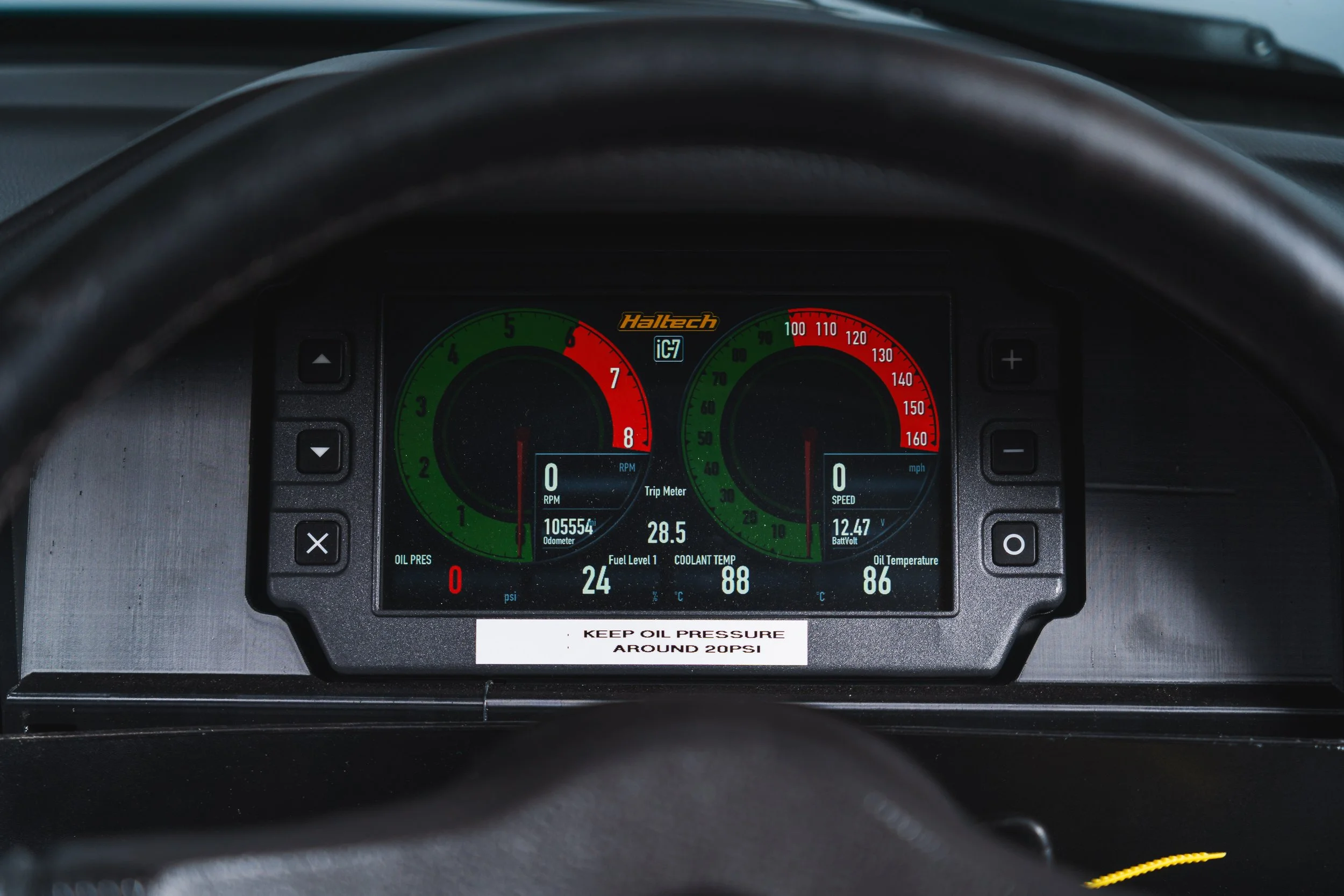 Digital dashboard of a vehicle displaying RPM, speed, odometer, trip meter, fuel level, coolant temperature, oil pressure, oil temperature, battery voltage, and oil pressure warning alert.