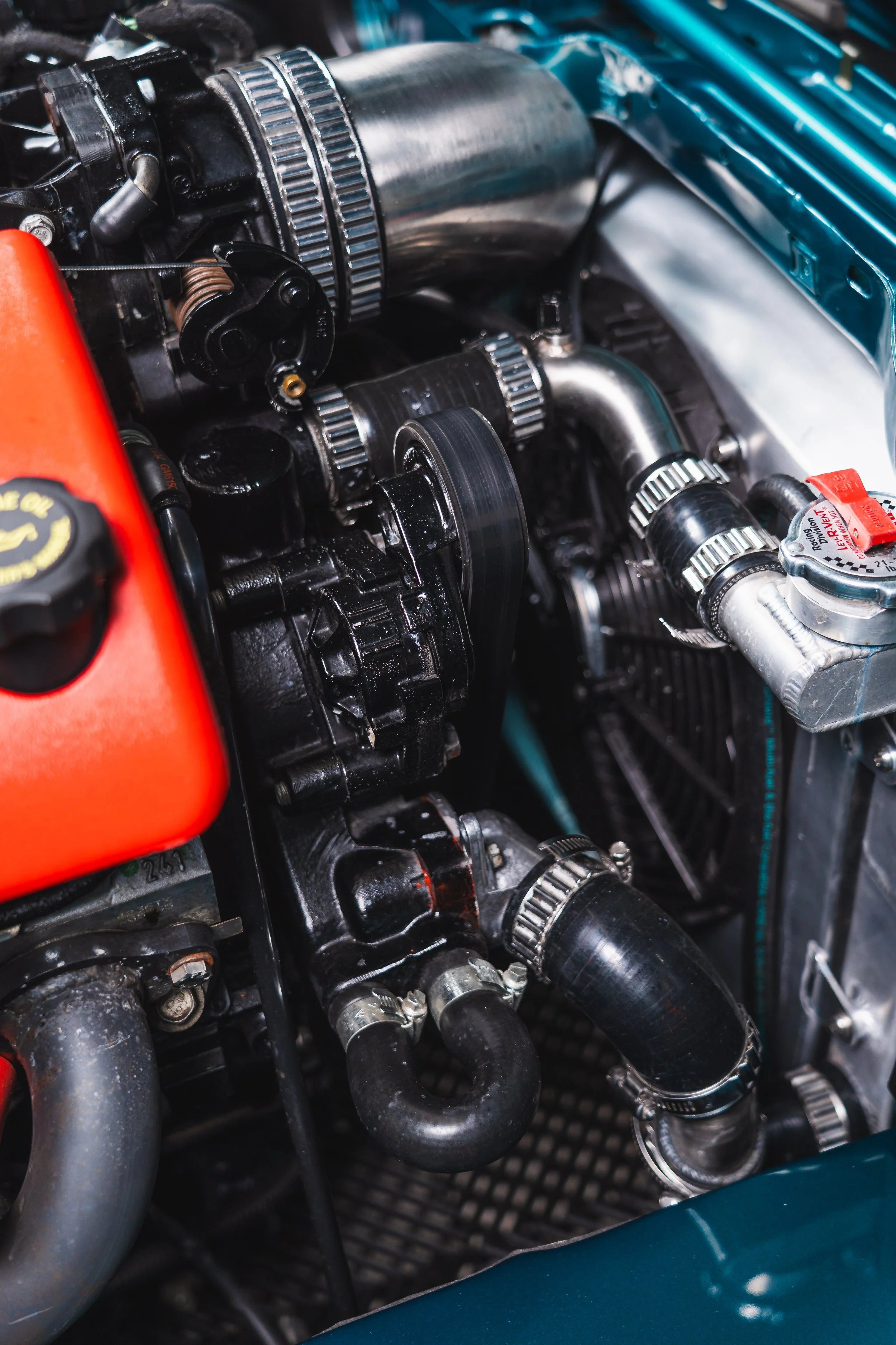 Close-up of a car engine showing belts, hoses, and various metal components.