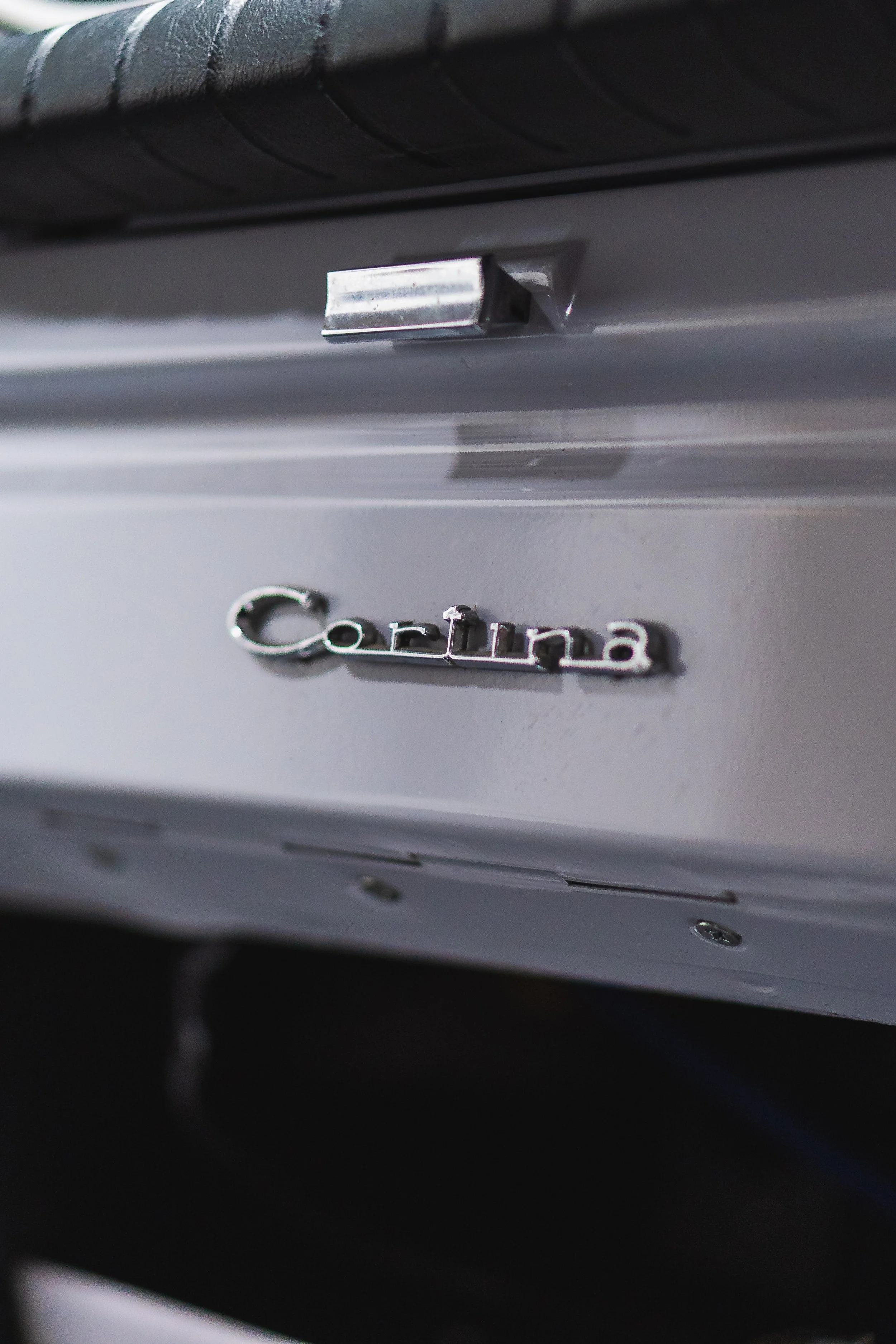 Close-up photo of a silver Cadillac logo on the back of a Cadillac vehicle.