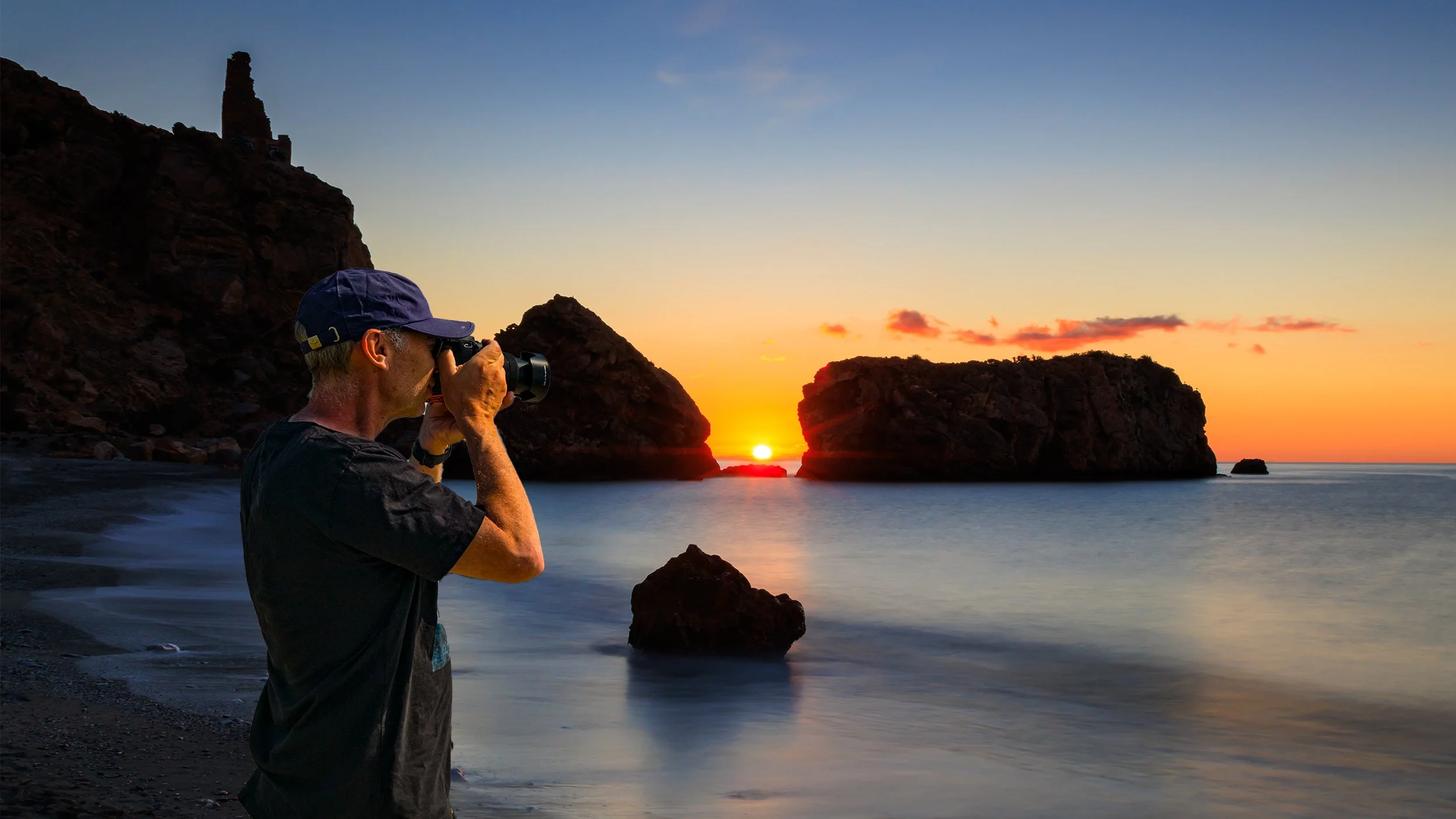 Andy H on location photographing landscape and wildlife to create fine art printscean with large rocky formations in the water.