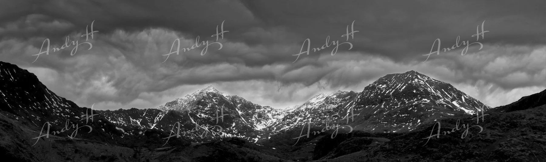 Landscape Photography fine art print, Black and white photo of snow-capped mountain peaks under a cloudy sky. Snowdon / Eryri peak and Crib Goch Ridgelines