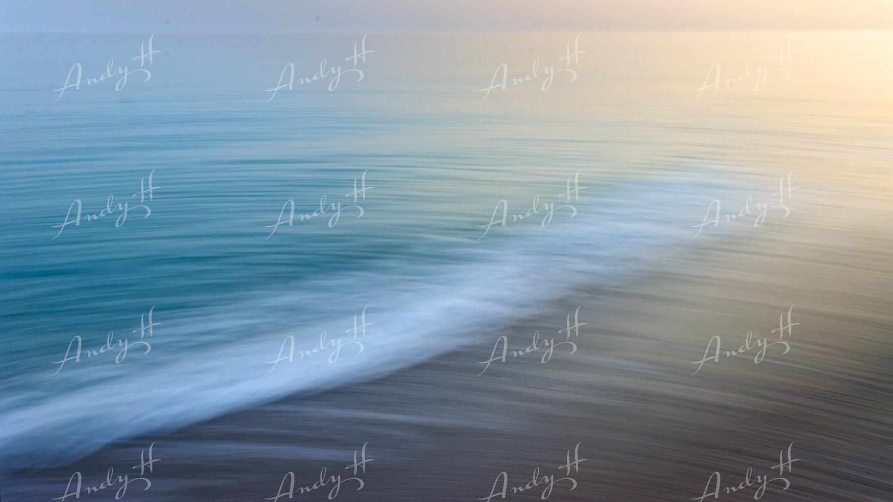 An abstract fine art print, calm ocean scene with a wave lapping against the shore, with a soft, pastel-coloured sky.