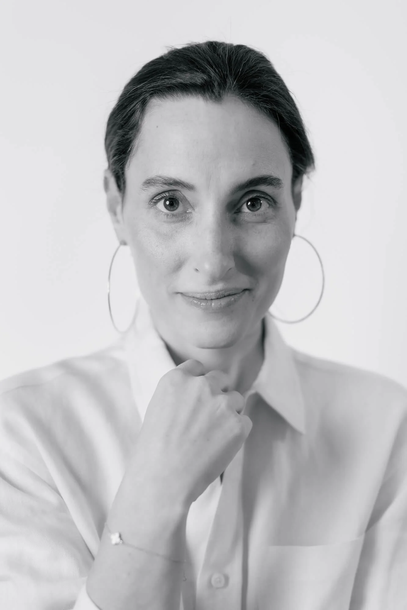 Alissa Friedlander, LCSW black and white headshot. her hair is a bun, large hoop earrings, white blouse looking directly at camera