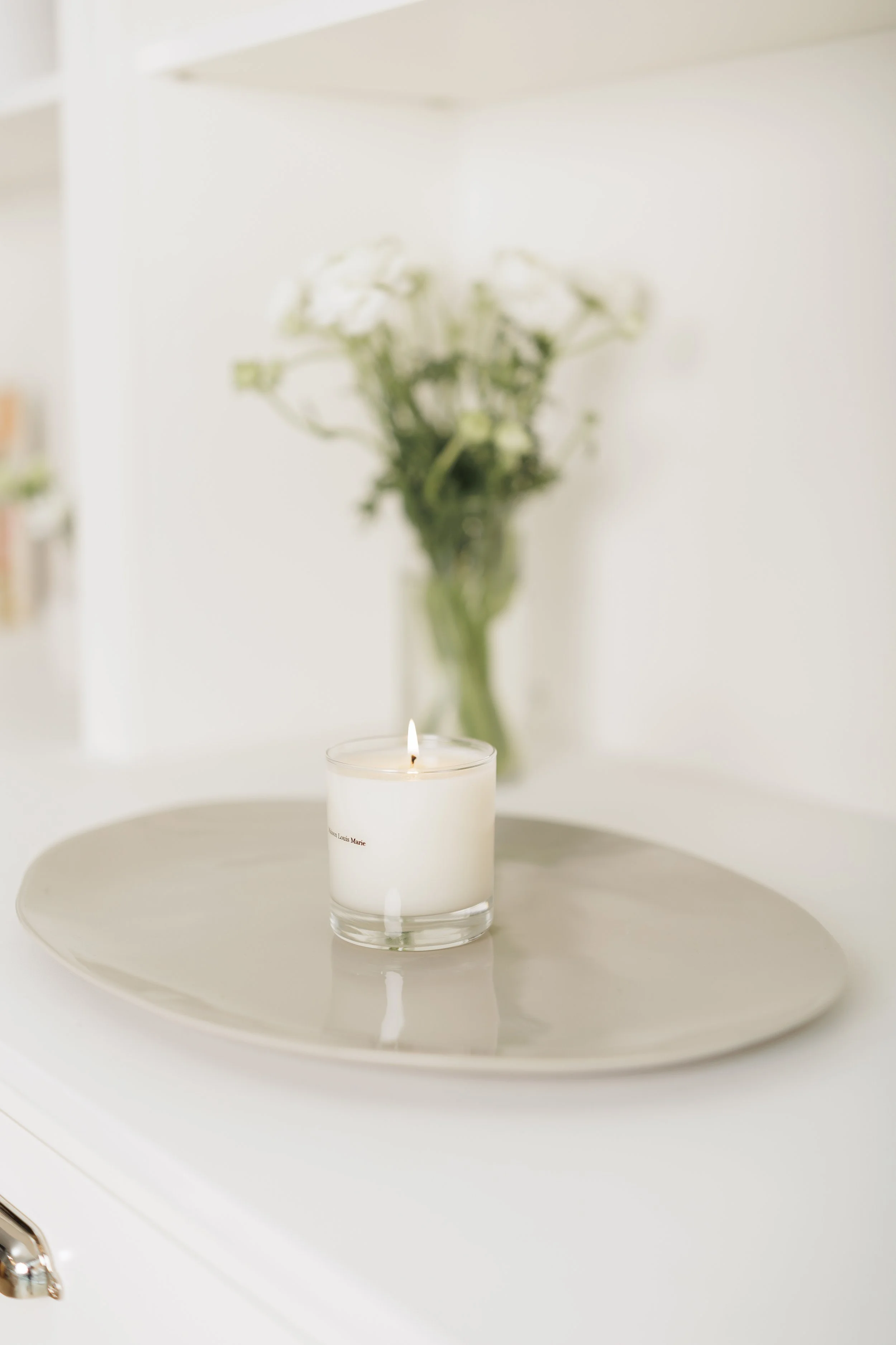 vase with flowers and candle on table top