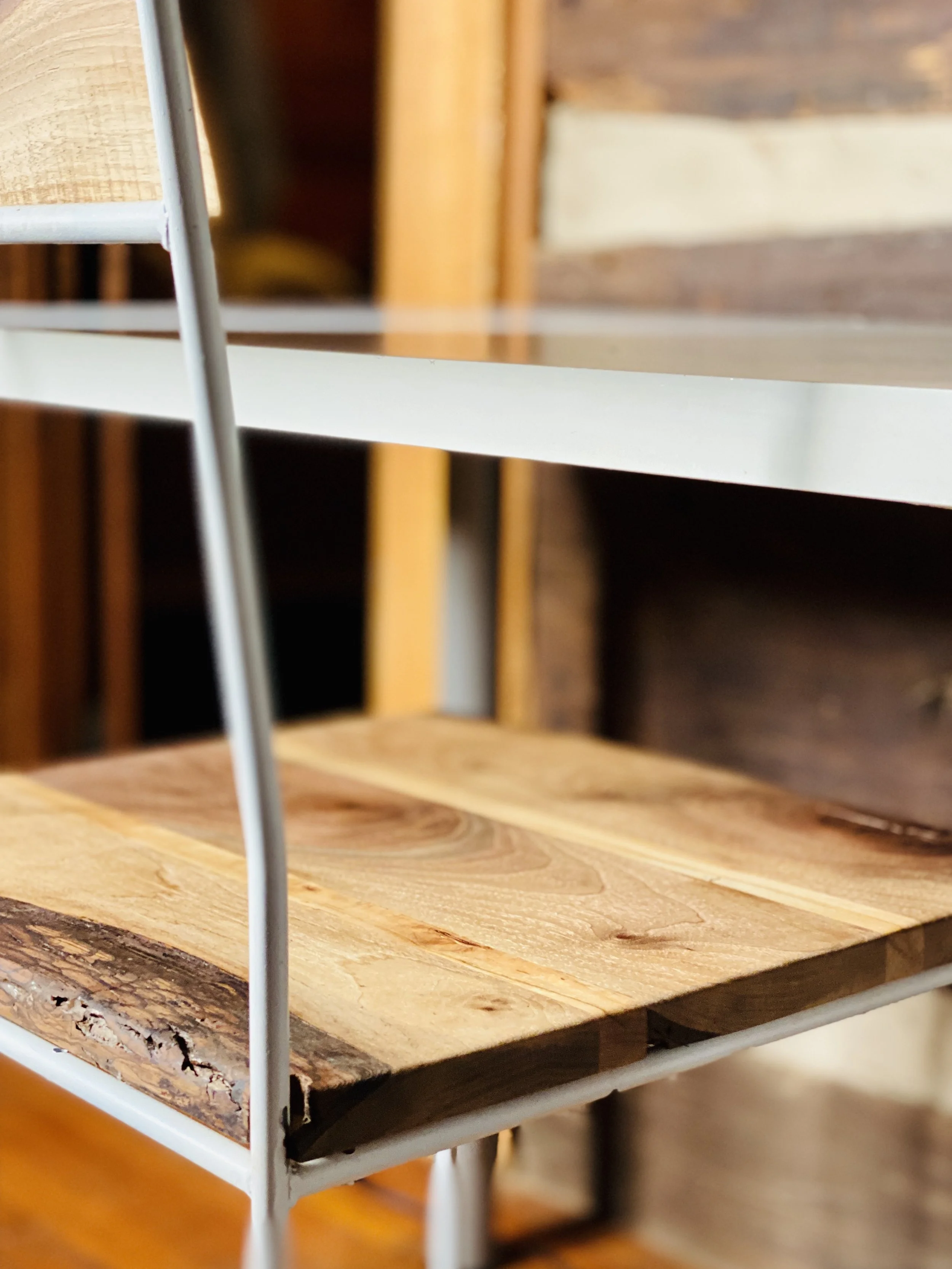 Close-up of a wooden shelf with a metal frame in a furniture store.