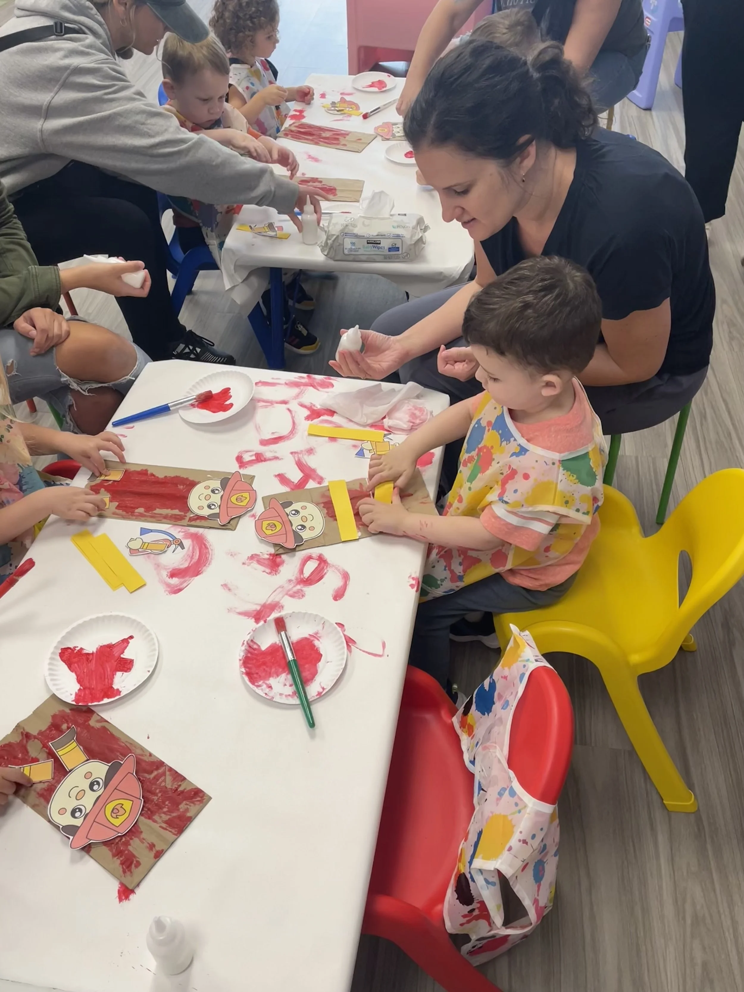 Children and adults creating a firefighter-themed art project together during a Kid Ka Doodle Little Doodlers class in Hunterdon County, NJ.