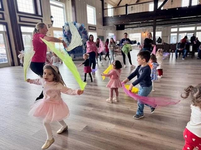 Children moving and dancing with colorful scarves during a Kid Ka Doodle Zumbini music and movement class in Hunterdon County, NJ.