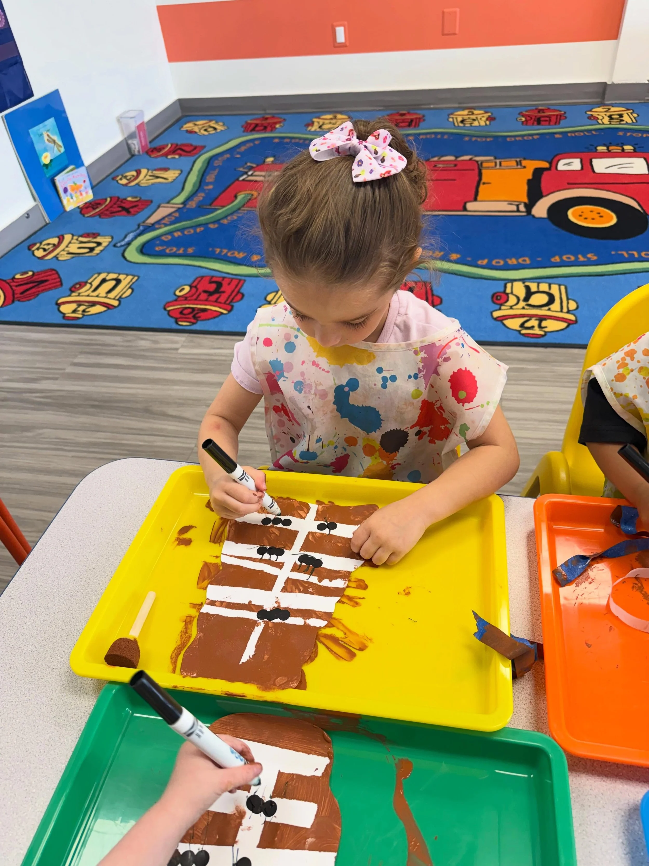Tape, sponges, and a whole lot of focus!

The Pre-doodle class created ant armies within the hills! Using art tape and sponges to paint right over it. 
Peeling back the tape revealed the hidden underground world of ant tunnels! A few sticker bodies a