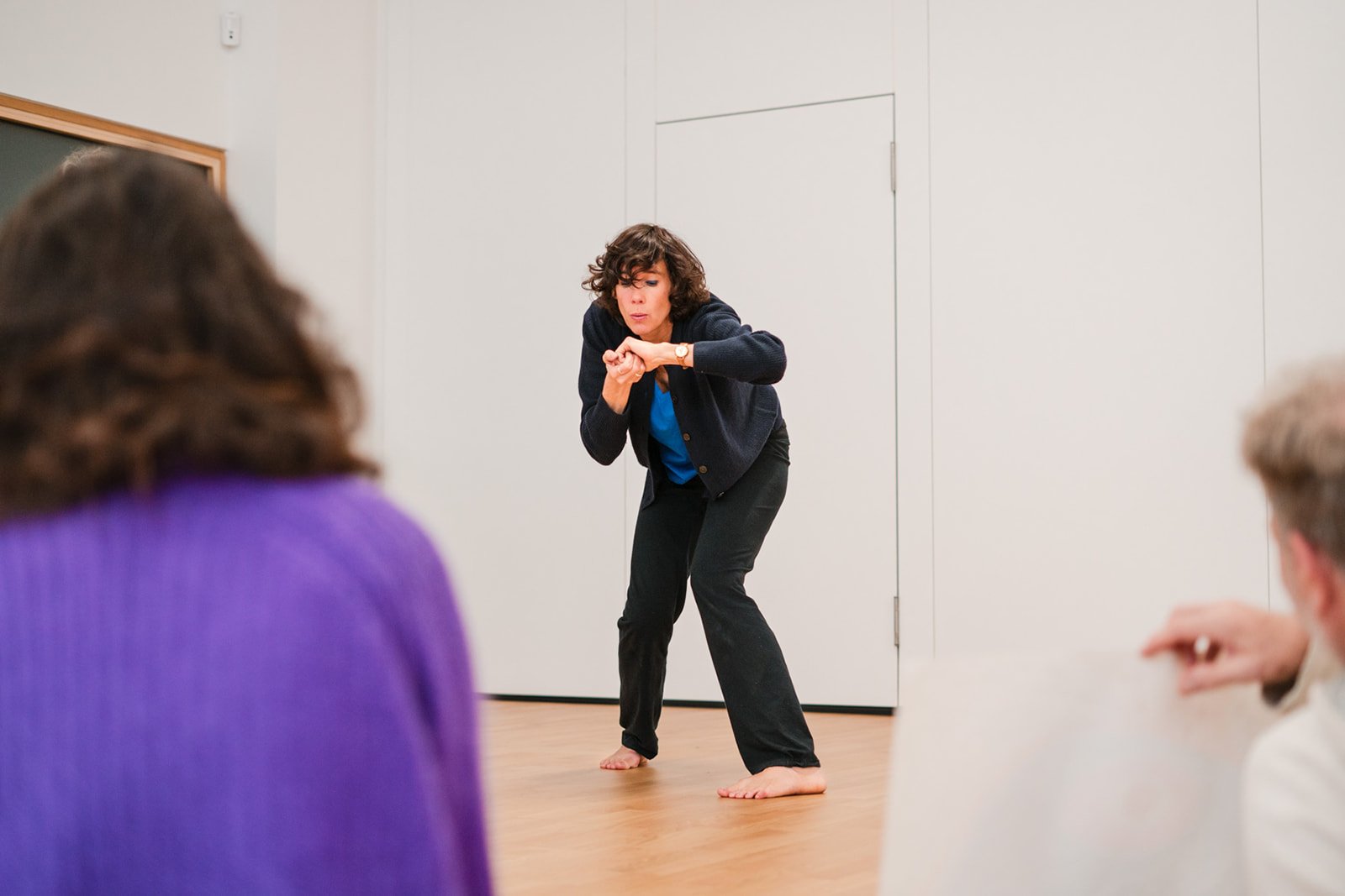 Une femme en train de danser devant des personnes assises, dans une pièce intérieure, lors des dimanches Life Art Process® de Stéphane Vernier.