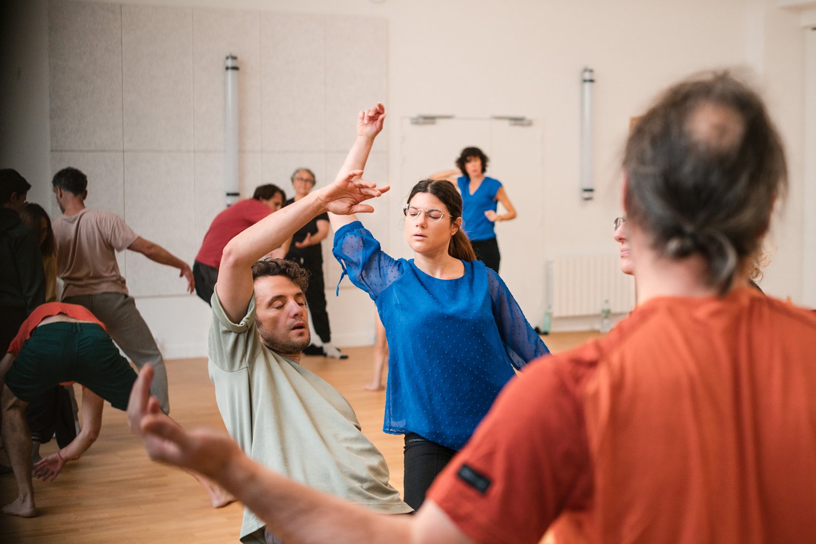 Des personnes dansent dans une salle de danse, concentrées et en mouvement, avec un fond de murs clairs et un sol en bois, lors des dimanches Life Art Process® de Stéphane Vernier.