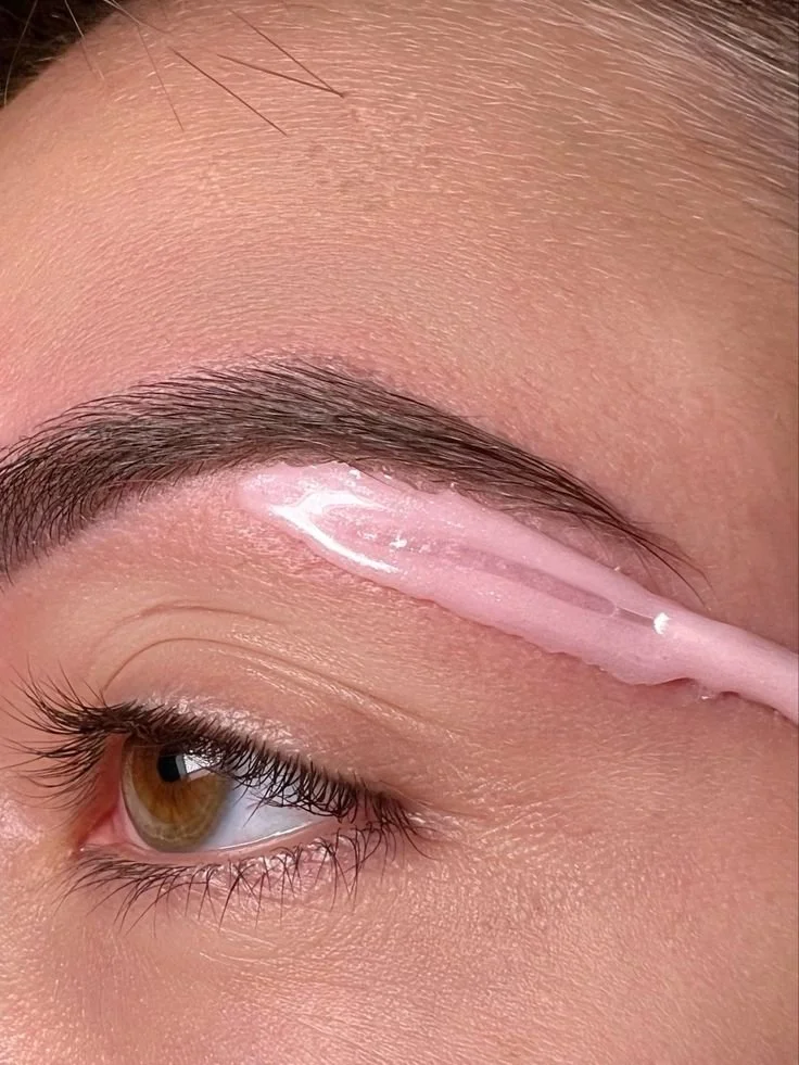 Eyebrow waxing in progress with soft wax application, shaping brows for precise, smooth hair removal results