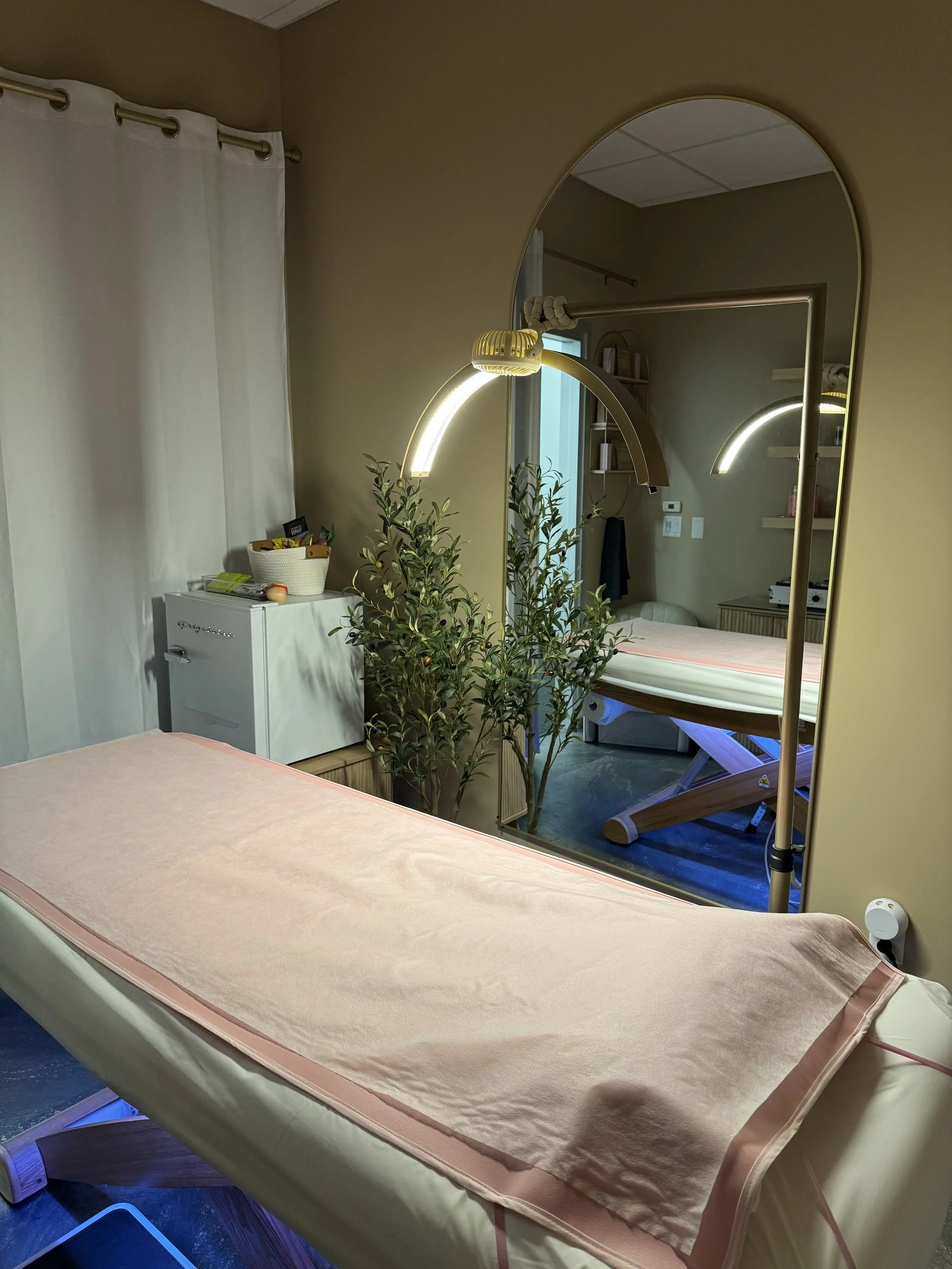 Brazilian waxing treatment room with esthetician table, professional waxing lamp, and clean spa setup for hair removal services