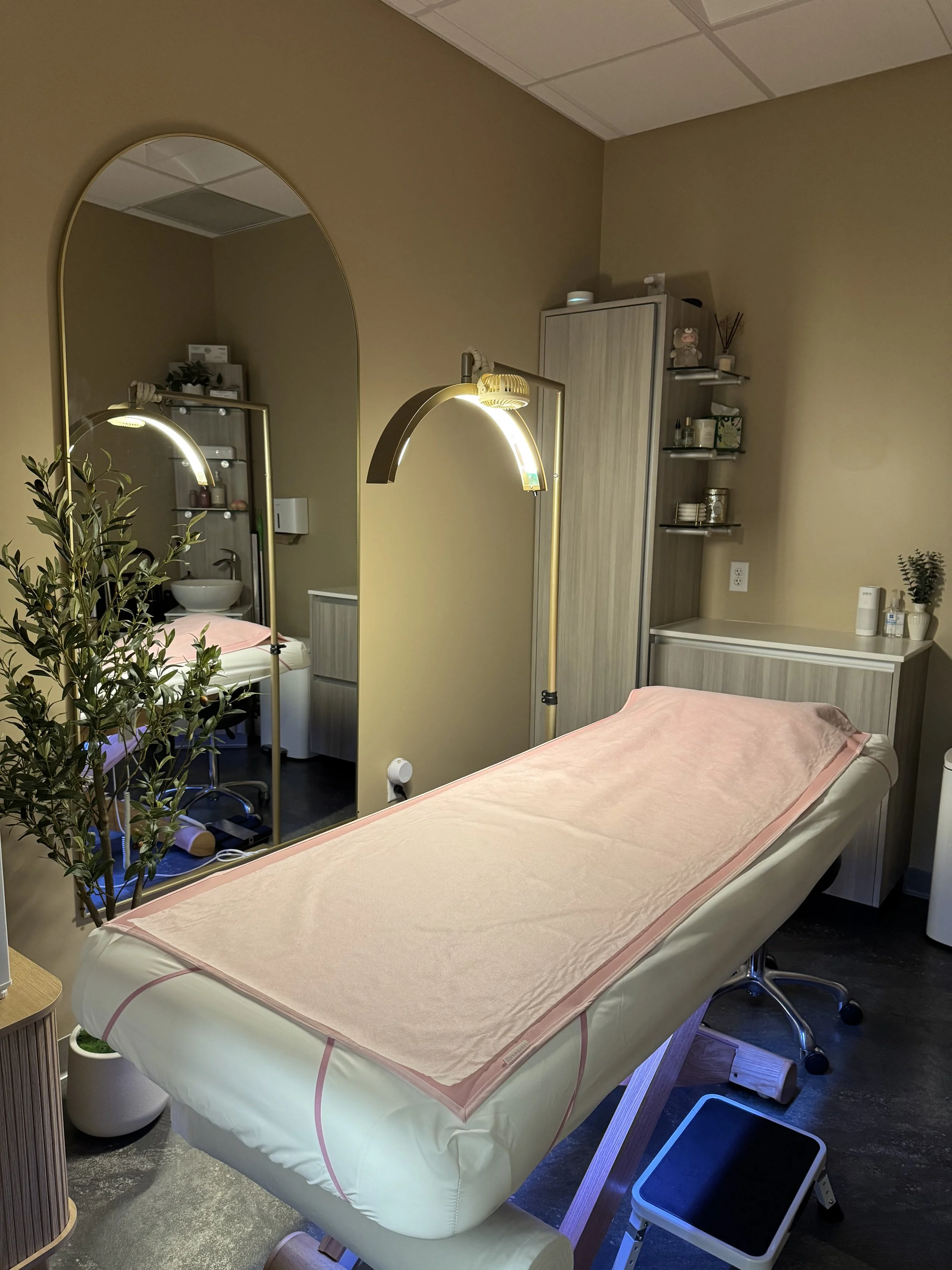 Brazilian waxing treatment room with esthetician table, professional waxing lamp, and clean spa setup for hair removal services