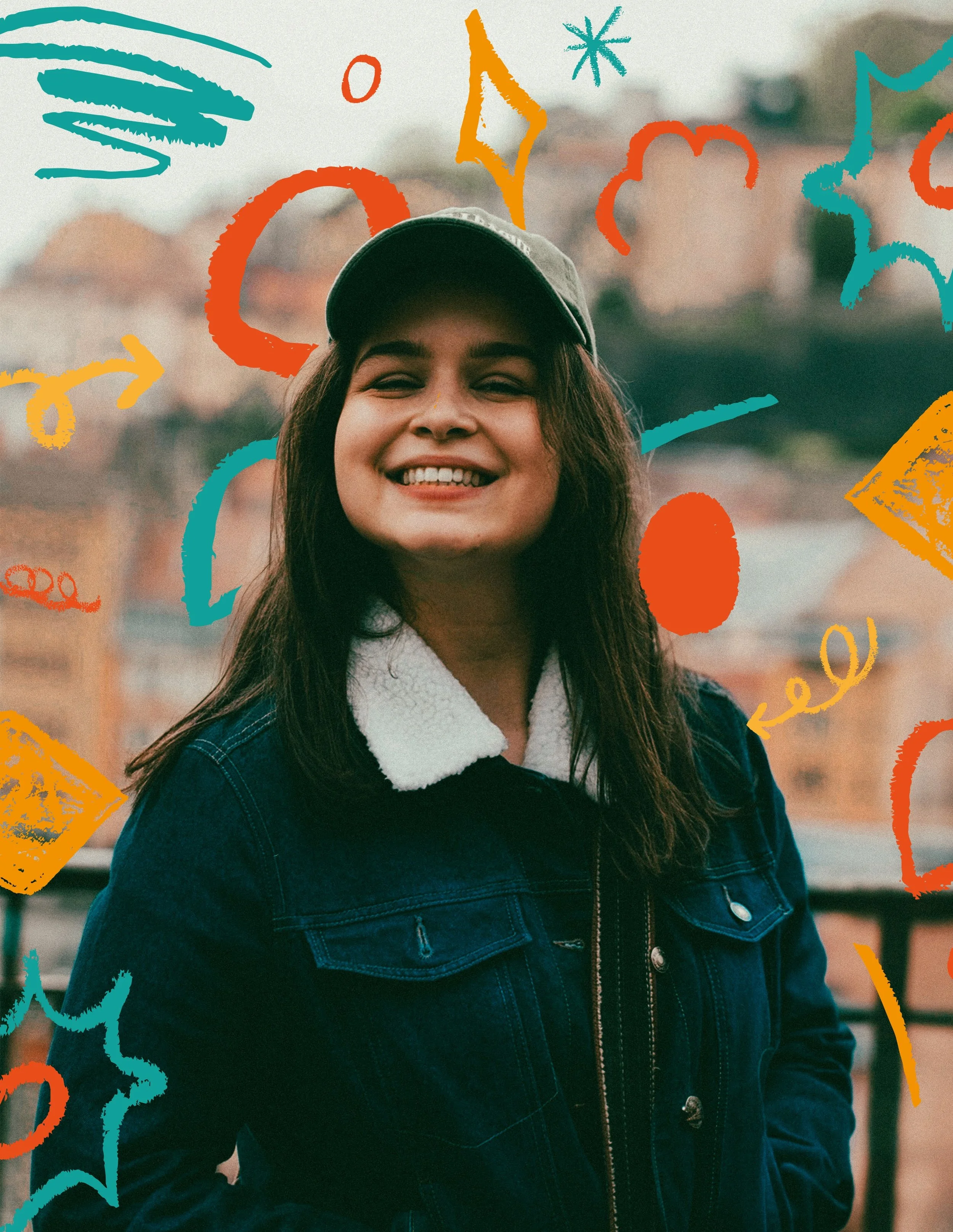 Jeune femme souriante portant une casquette et une veste en jean, en extérieur avec un fond flou de bâtiments, décorée de dessins colorés et abstraits en premier plan.