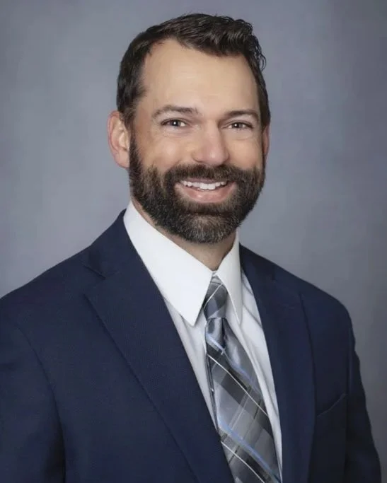 Professional business headshot of male executive in Amarillo Texas wearing navy jacket and tie