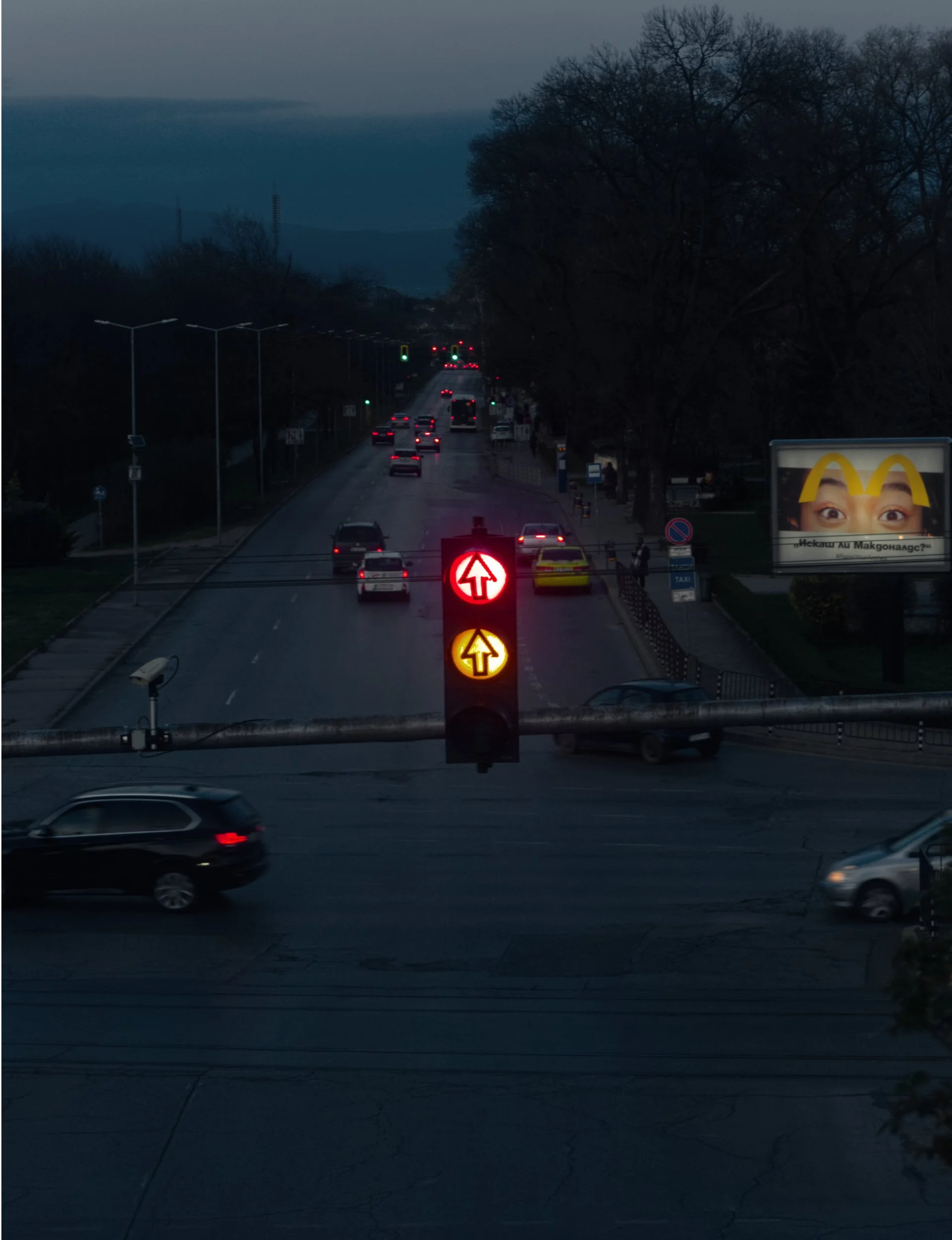 Traffic lights in Sofia, Bulgaria. Billboard with a face and McDonald's logo visible in the background.