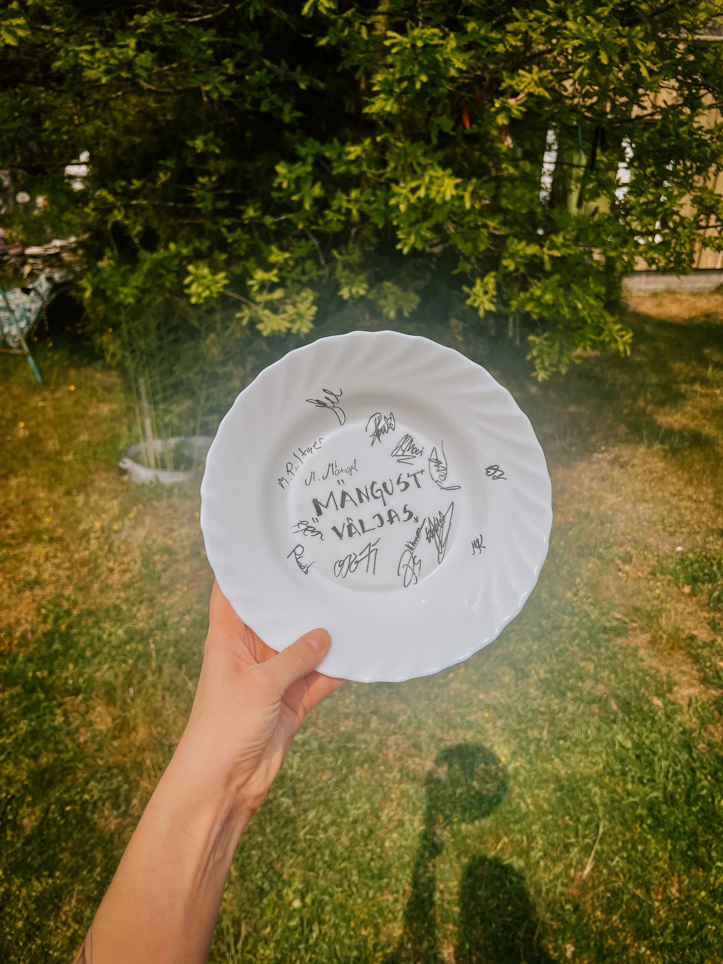White plate with signatures and the name of the movie "Out of the game"