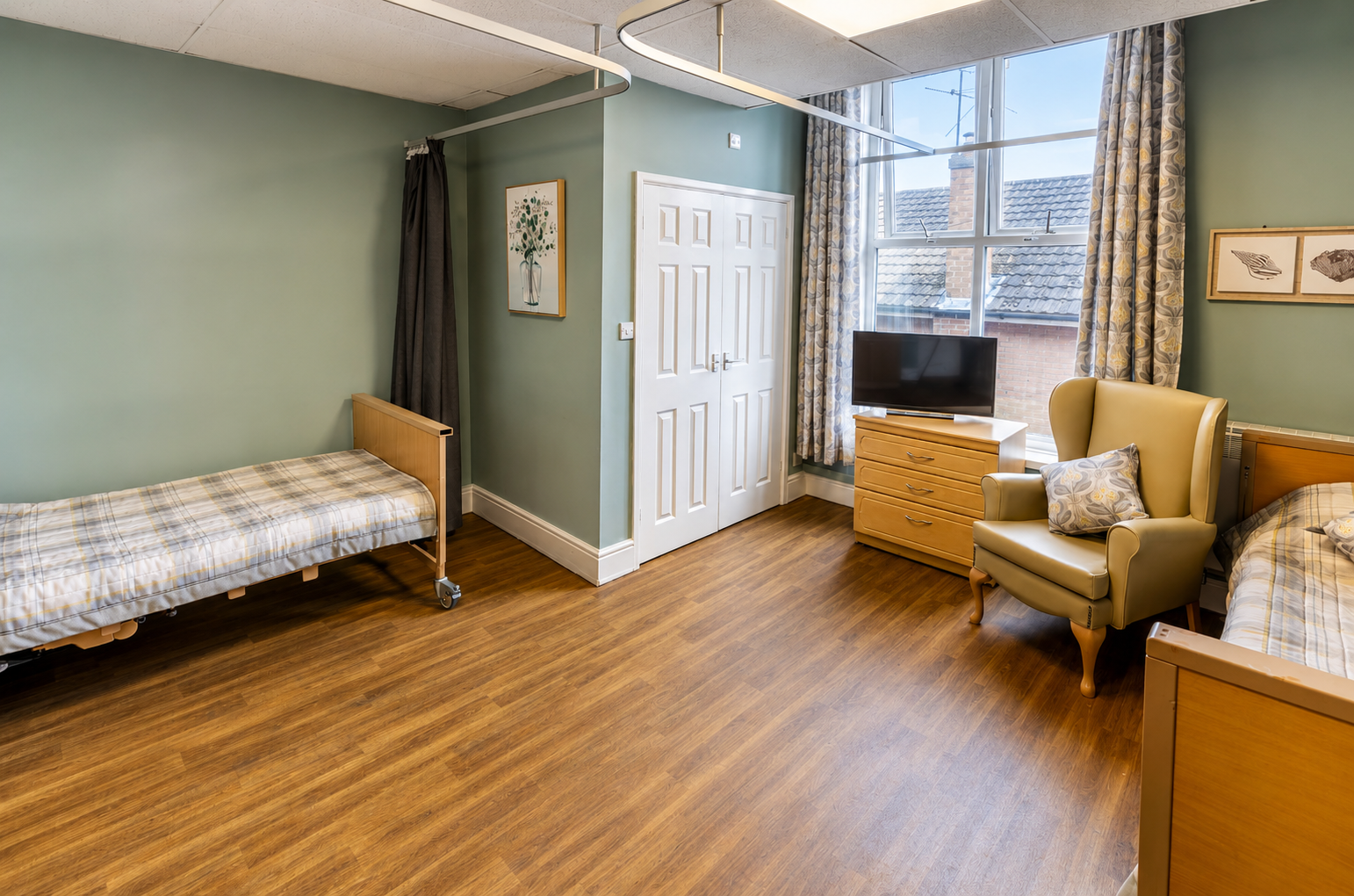 A shared room with two beds, both with modern plaid bedding at Croft Care Home in Burton on Trent