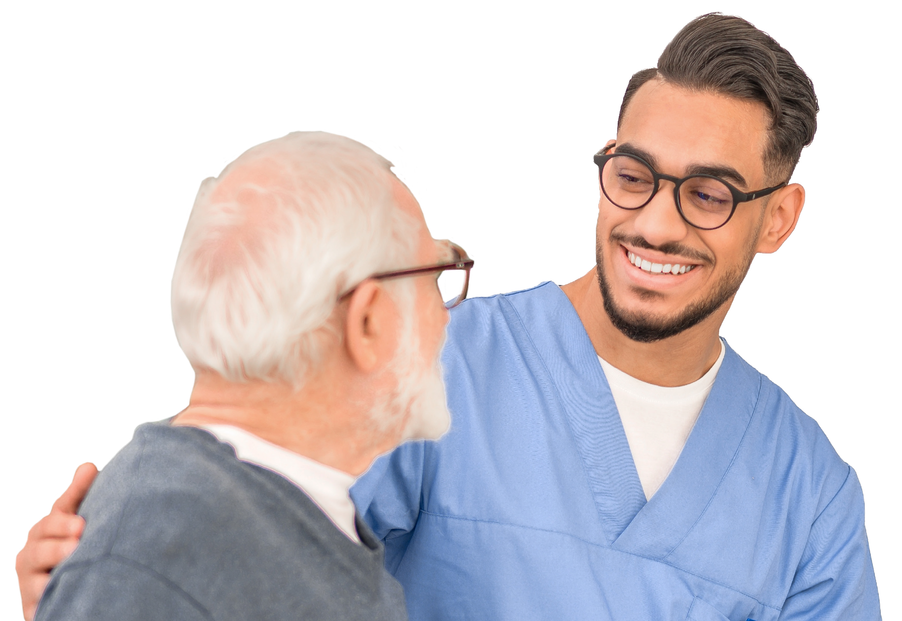 A young man in medical scrubs smiling and hugging an older man with white hair and glasses.