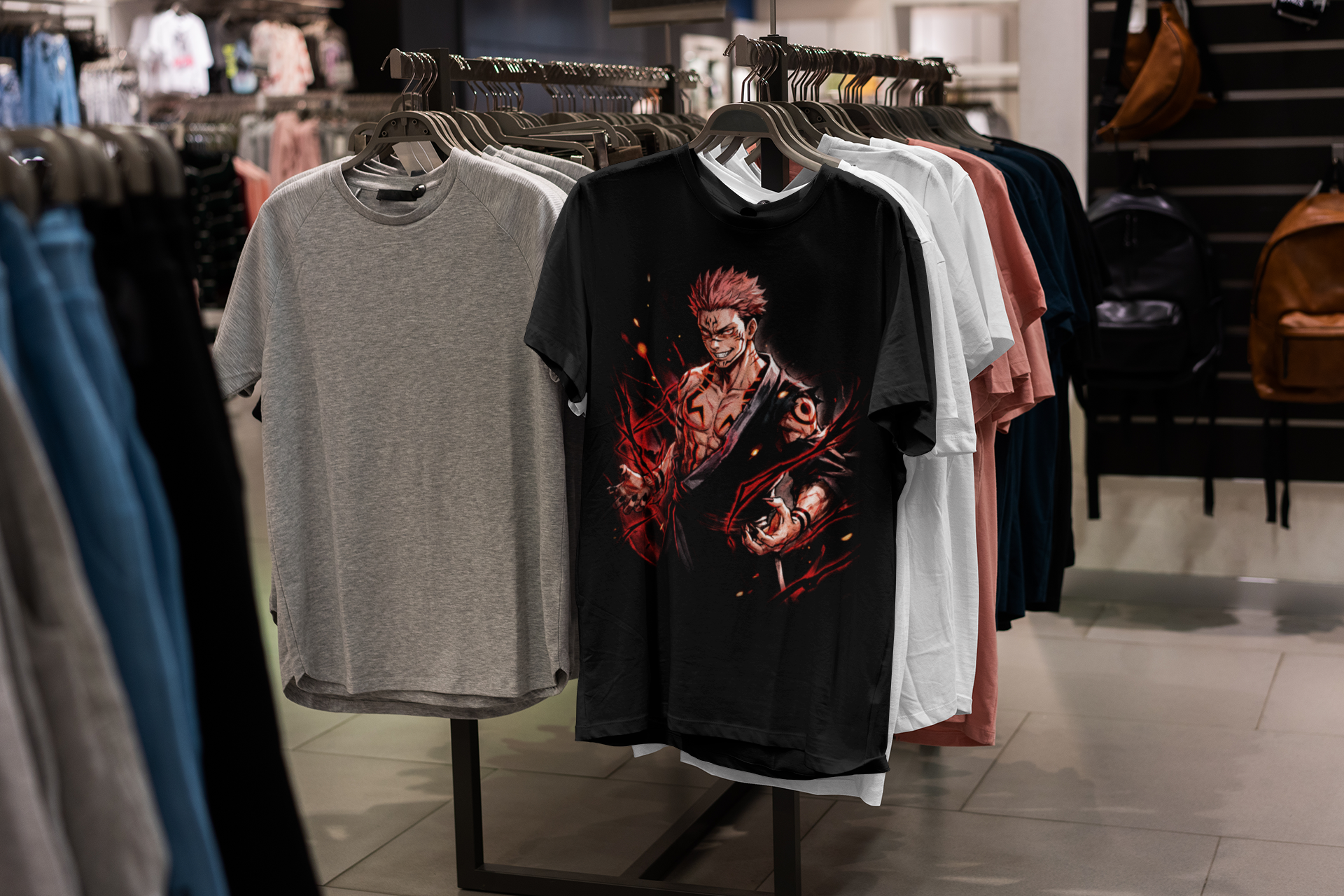 Clothing store display featuring graphic T-shirts, with a black T-shirt showcasing a stylized animated character with spiky hair and a mischievous expression, among other plain and colored T-shirts.