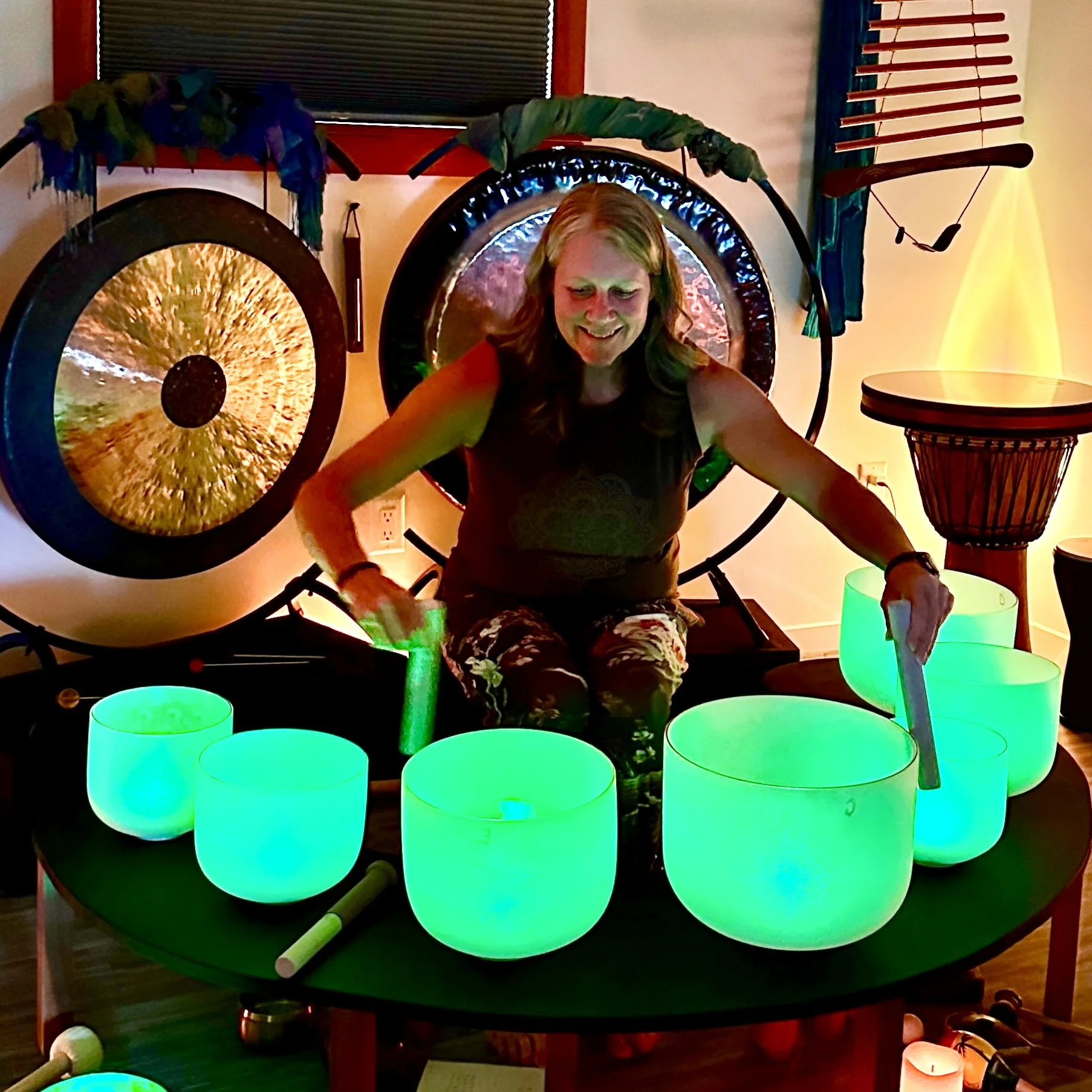 Michelle Koster surrounded by sound healing instruments at Enchanted Studios.