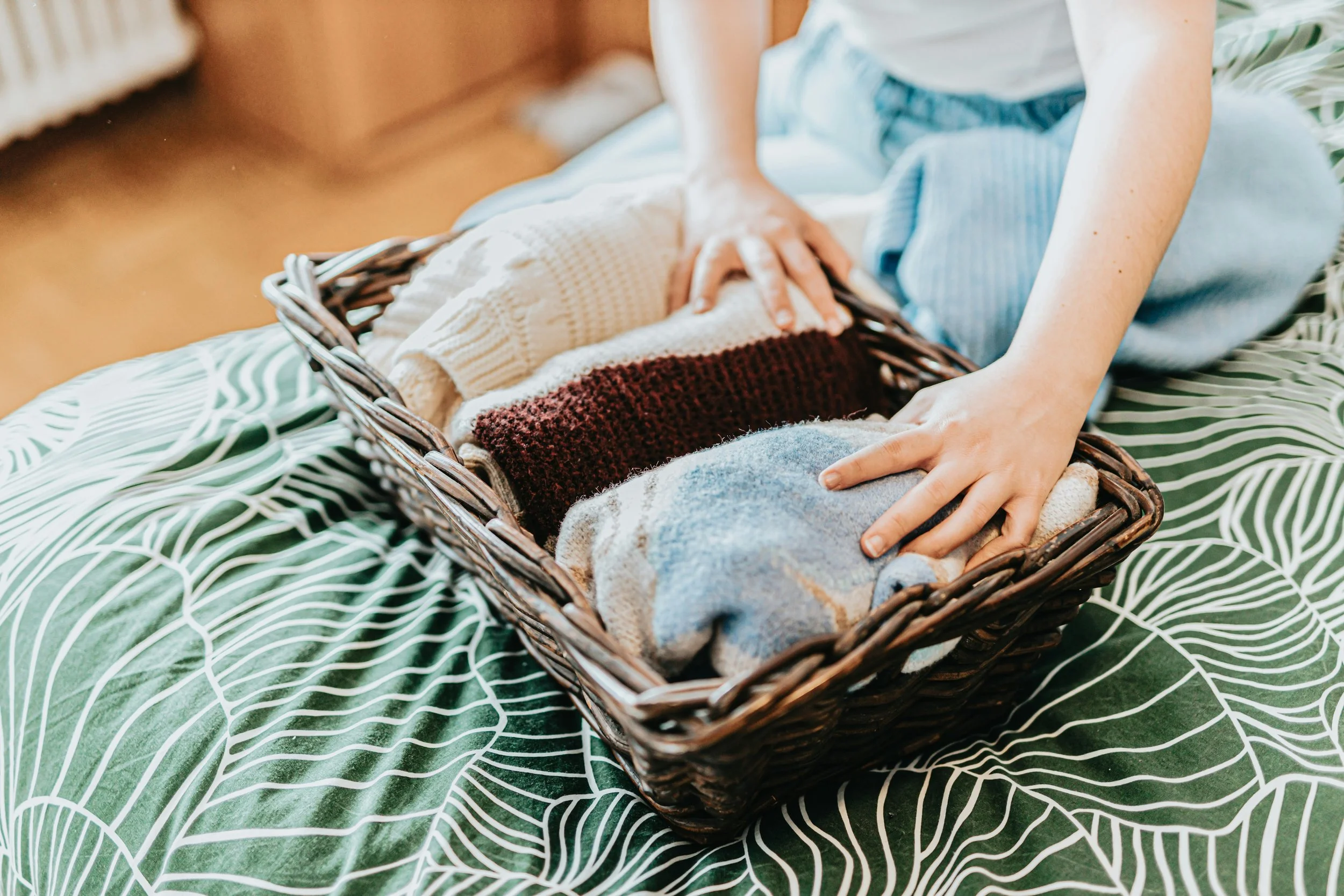 Professional organizer in Charlotte, NC putting clothes in a basket
