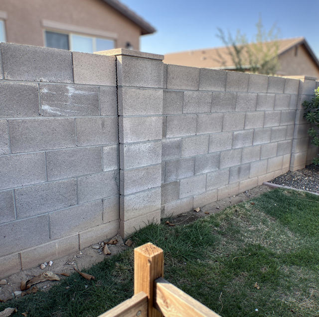 cracked leaning concrete block wall in residential side yard
